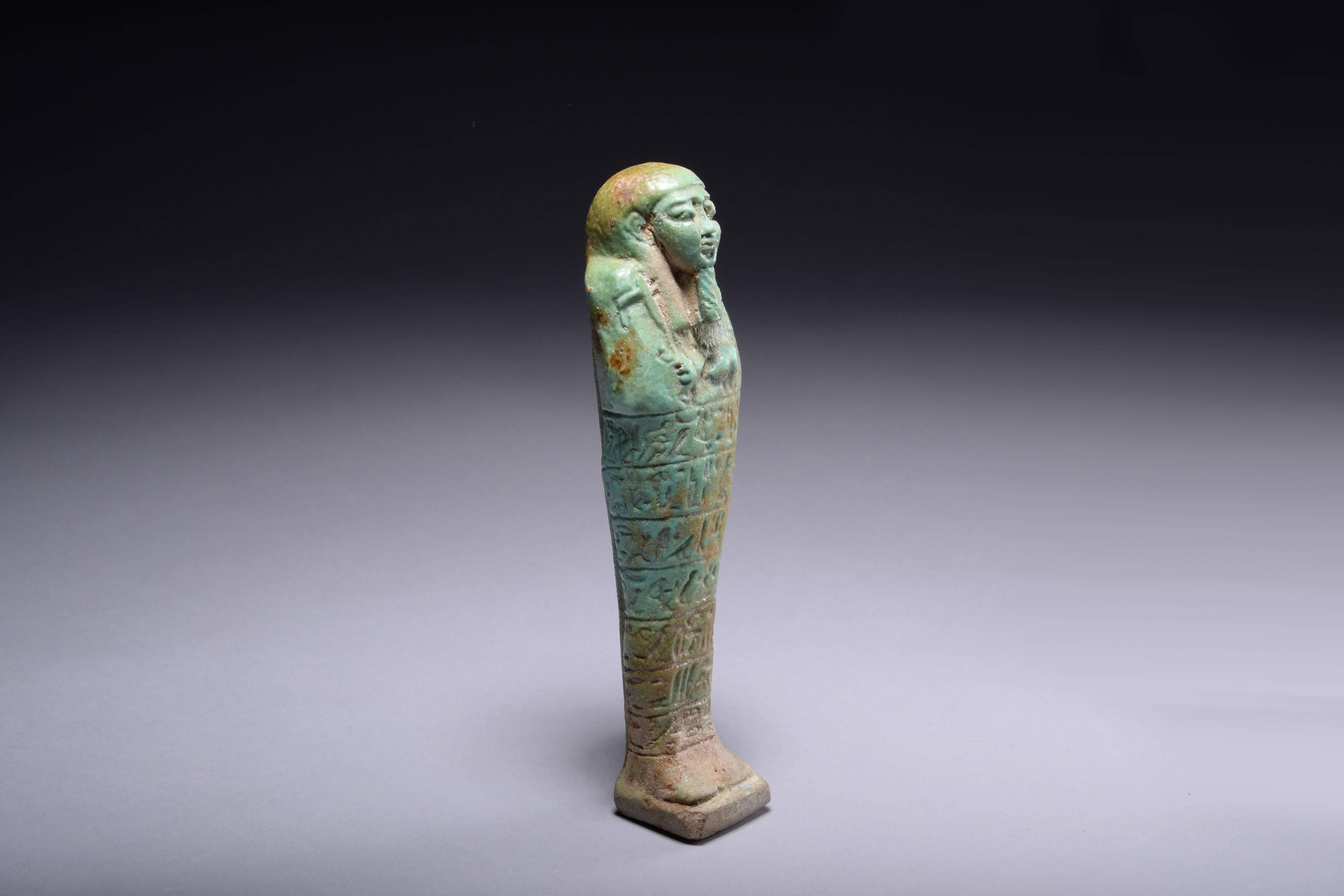 A large and rare ancient Egyptian green faience shabti for Hor-si-ast, son of di(t)-hor, dating to the late period, approximately 664-332 BC.

A substantial shabti, modelled in beautiful green faience, with seven rows of hieroglyphic text naming