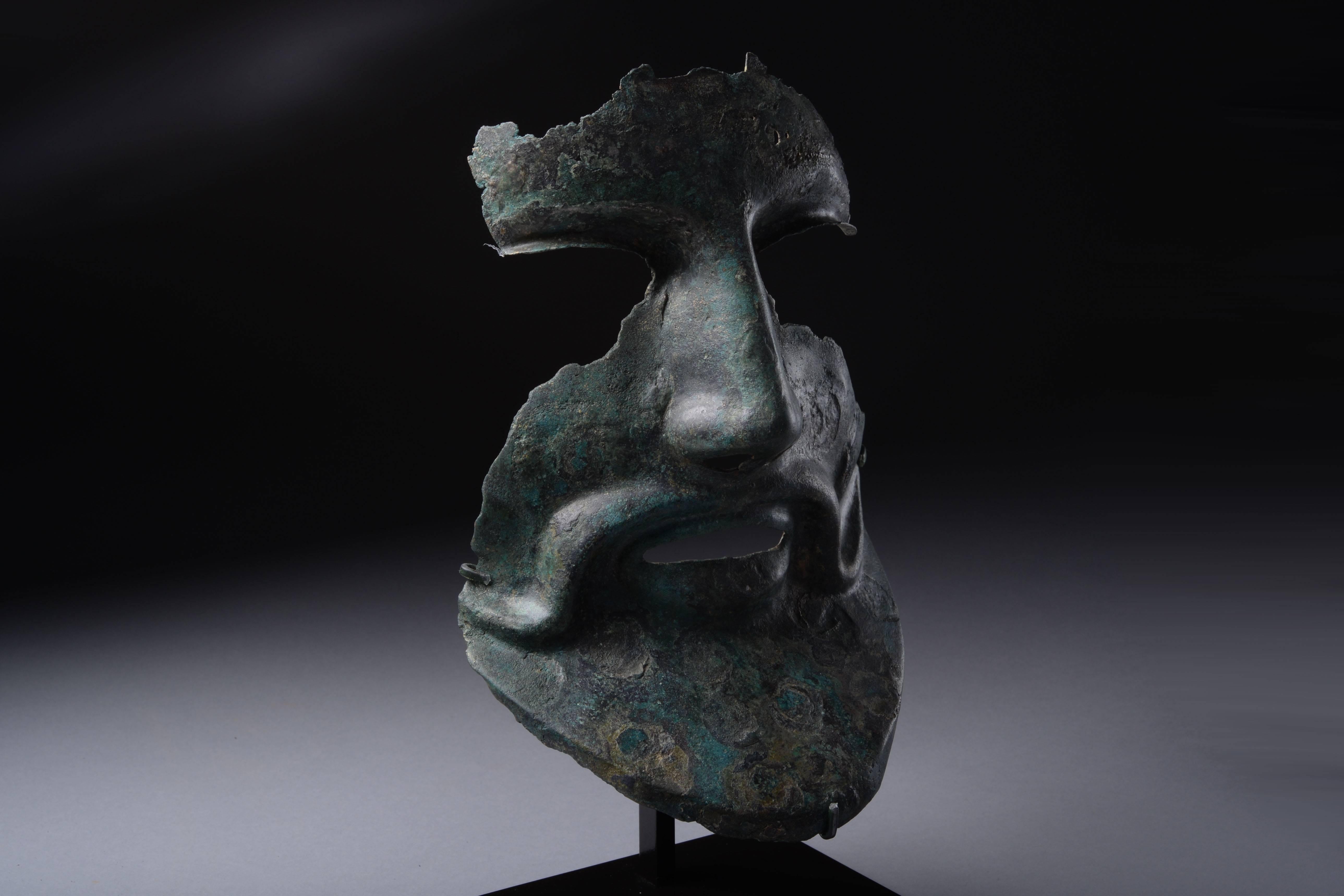 An extremely rare Greek bronze helmet fragment, dating to the late Classical to early Hellenistic Period, 350 BC.

Of hammered bronze, this fragment would originally have formed part of the face mask of a Phrygian helmet. Though separate