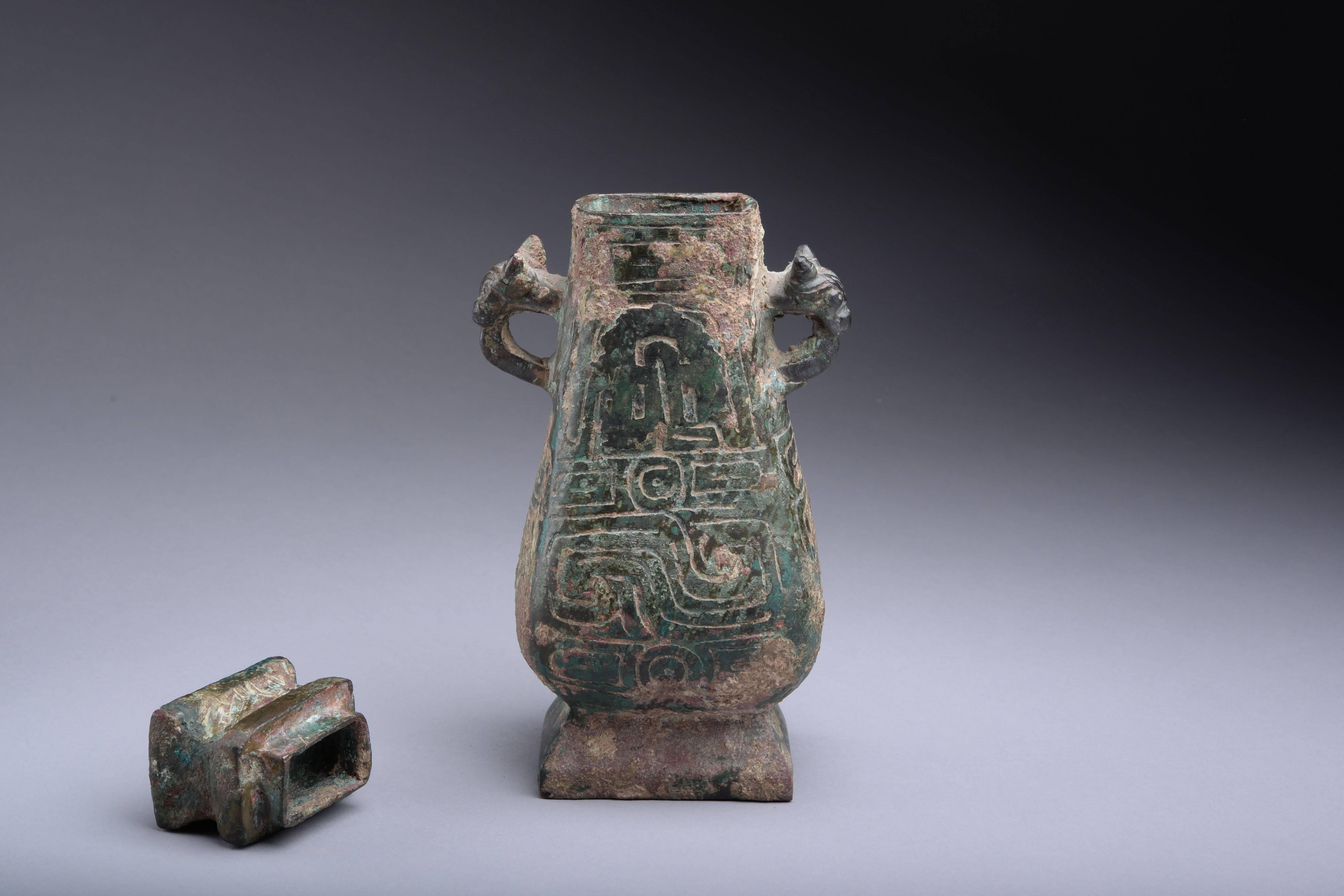 An ancient Chinese ritual bronze food vessel, or Hu, dating to the Western Zhou period, circa 800-700 BC.

Cast in bronze, the vessel with pear shaped body, flaring rectangular base, straight lip and separately cast lid. The circular handles with