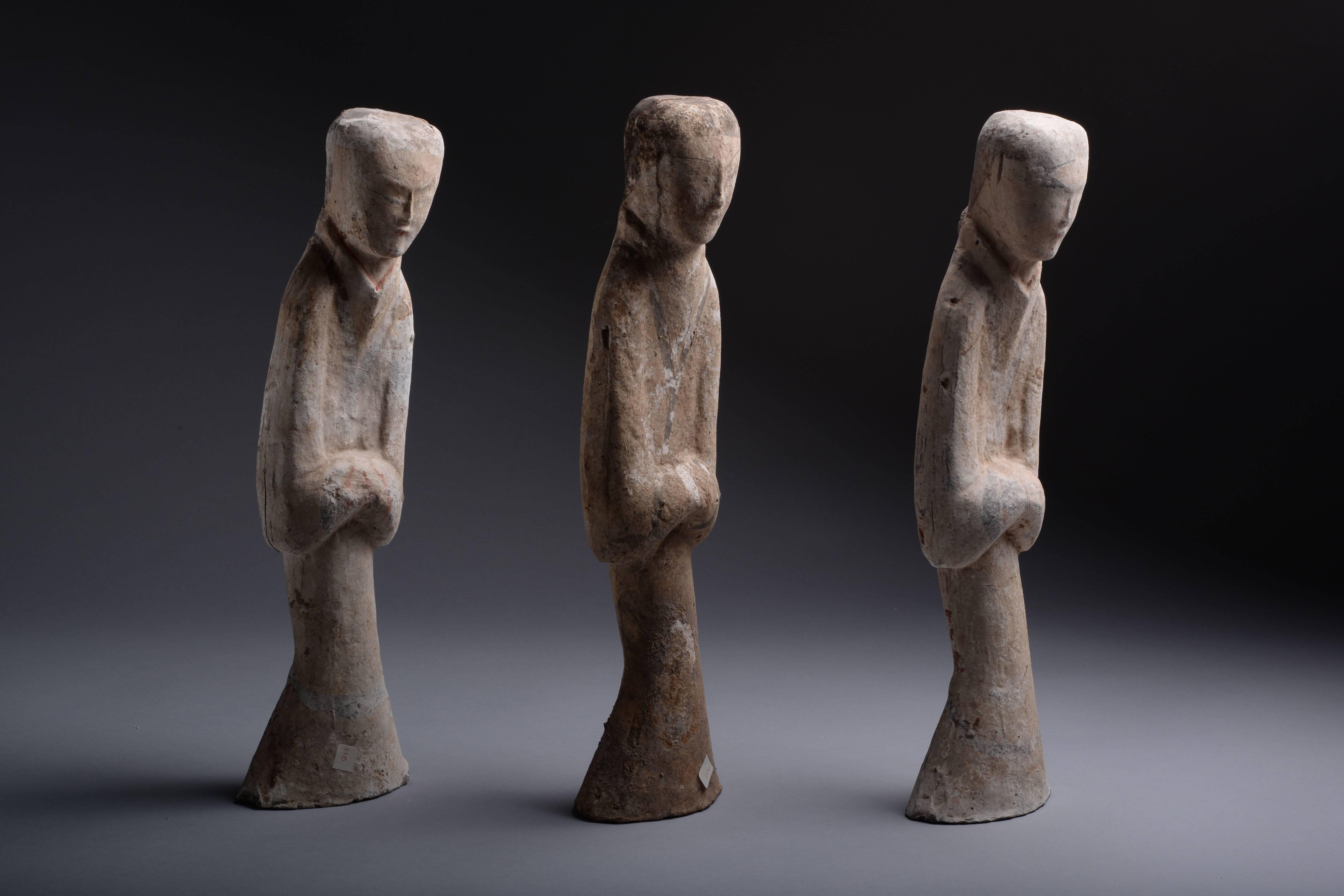 A beautiful group of three ancient Chinese Han dynasty terracotta figures, dating to 206 BC-220 AD.

These three figures, showing attendants all with their heads slightly bowed and hands held together, are exceptional in terms of their form,