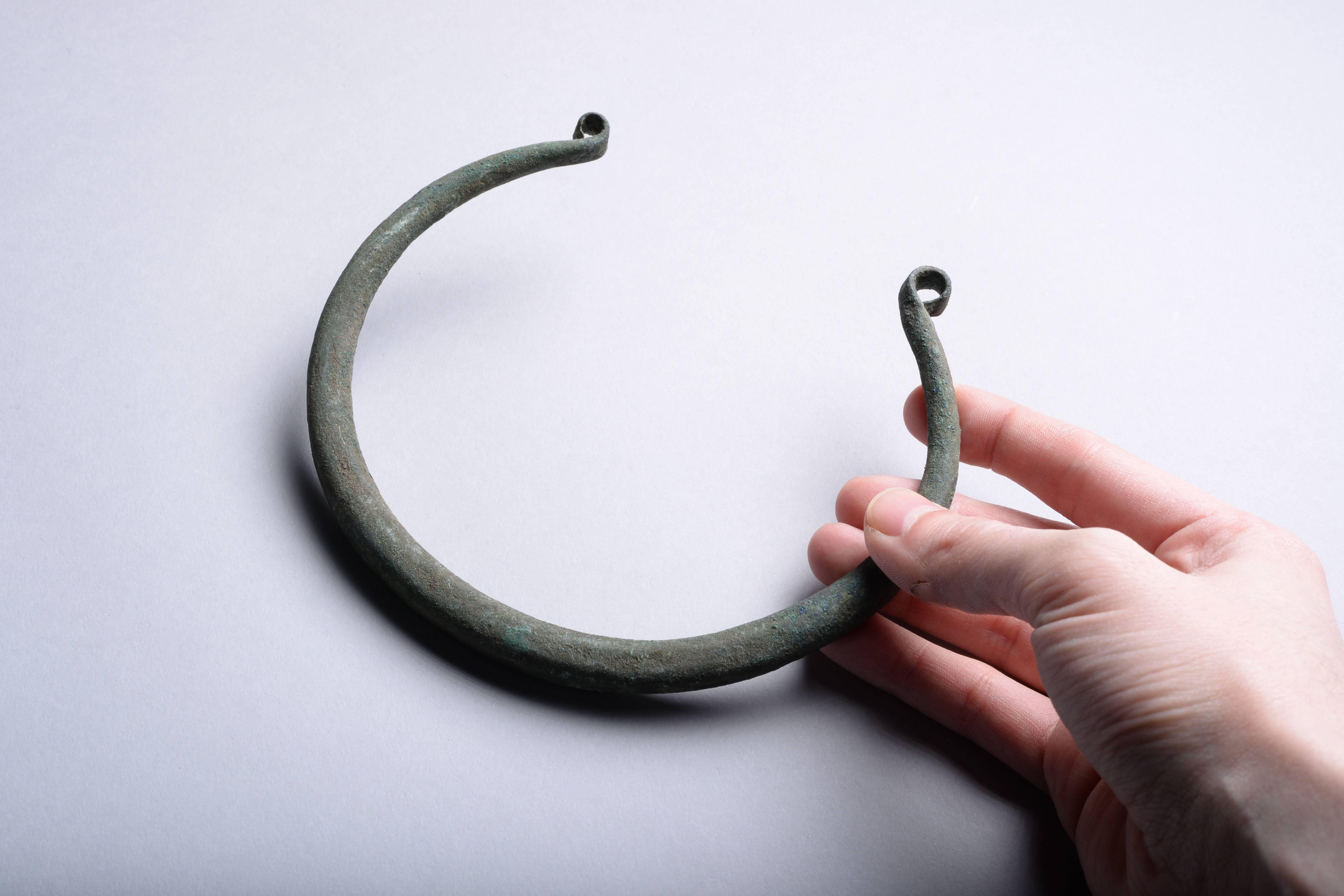 An elegant European copper alloy torc, dating to the 9th century BC.

Of typical penannular form, the terminals hammered flat and bent into curls, giving the piece a wonderful aesthetic.

Torcs were status objects worn around the neck by the