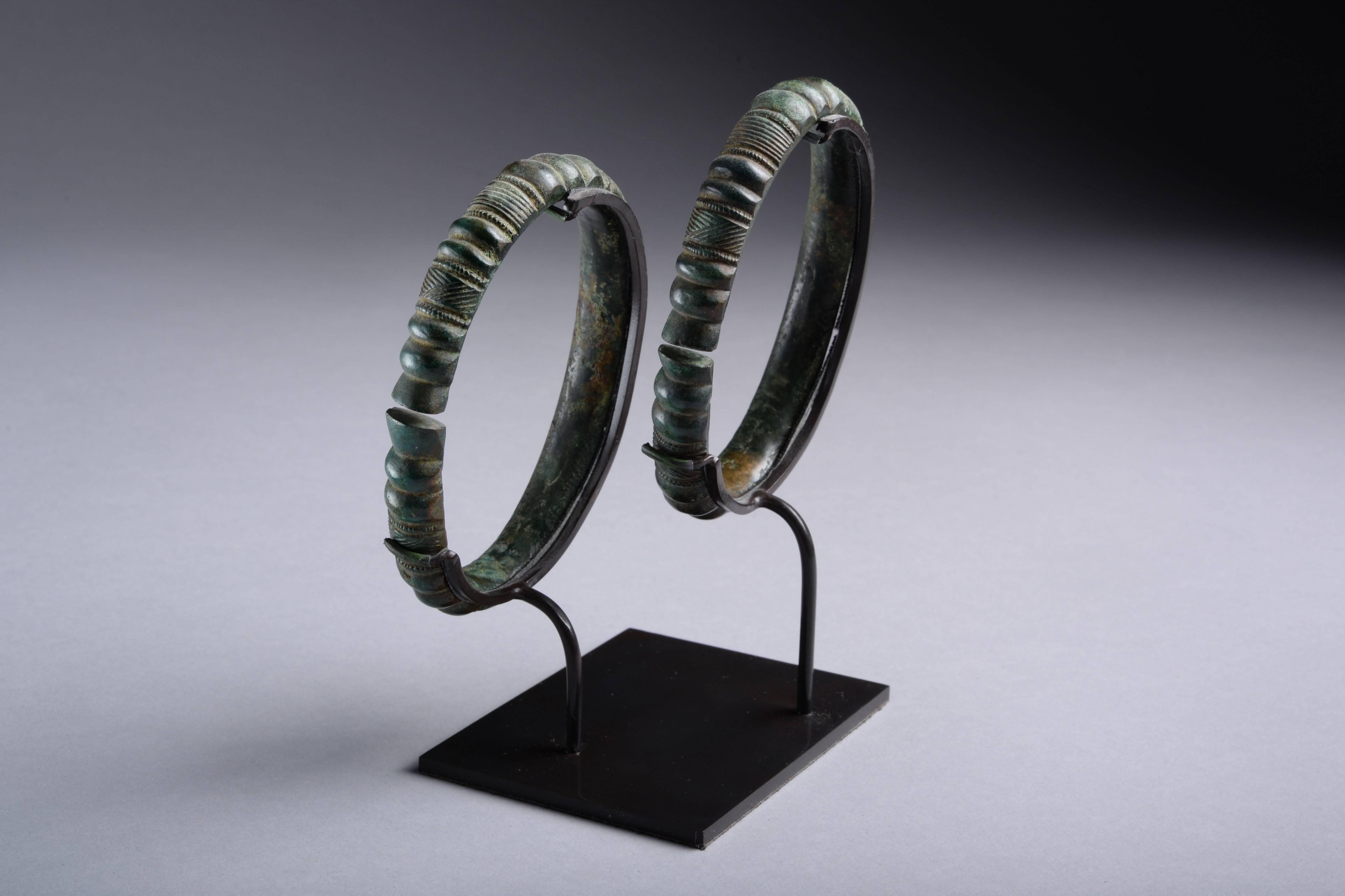 These beautiful European Iron Age bangles are exceptionally well manufactured and preserved. Dating to the Hallstatt period (9th - 7th century BC).

With an attractive dark green patina and decorated in confident style with simple lobes and