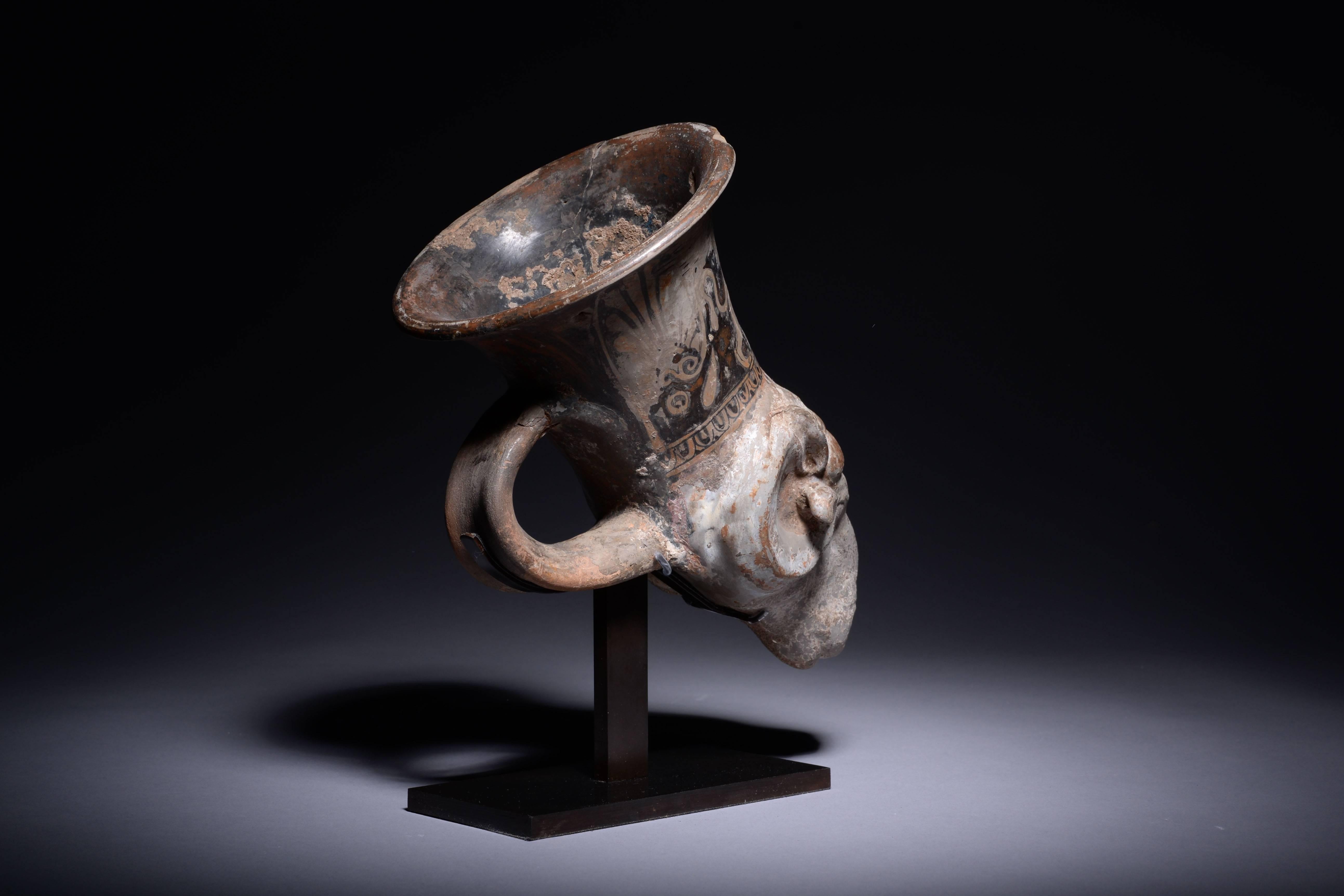 An ancient Greek Campanian pottery rhyton or drinking vessel, dating to circa 350 BC.

The lower part beautifully modelled in the form of a ram's head, the creature with curled, ribbed horns and folded back ears. The neck of the vessel painted in