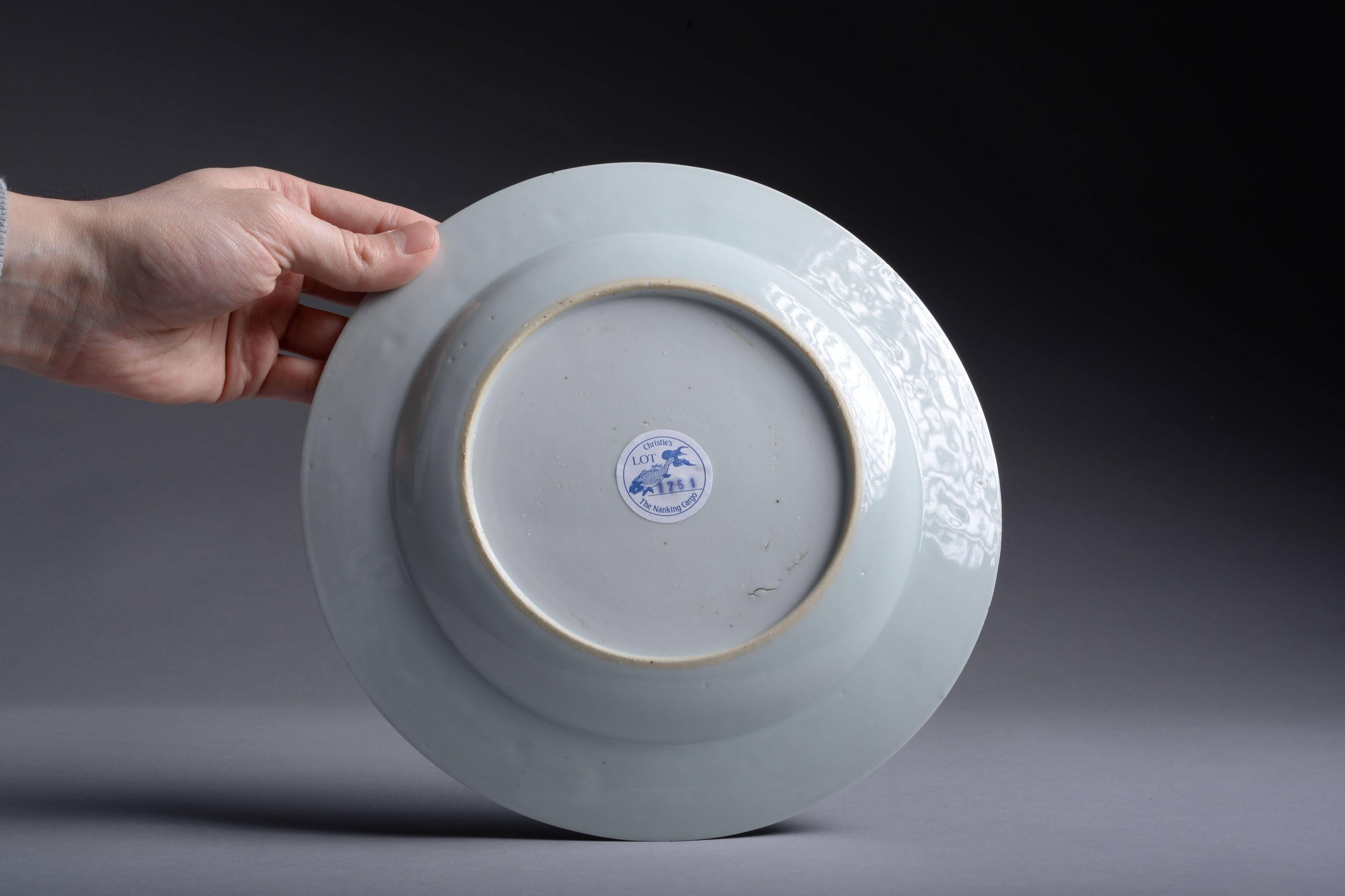 A wonderful, vibrant, Chinese blue on white porcelain dinner plate, dating to circa 1750 and salvaged from the famous Nanking cargo - an officially recorded piece with Christie's sticker and inventory number.

The centre of the plate is decorated