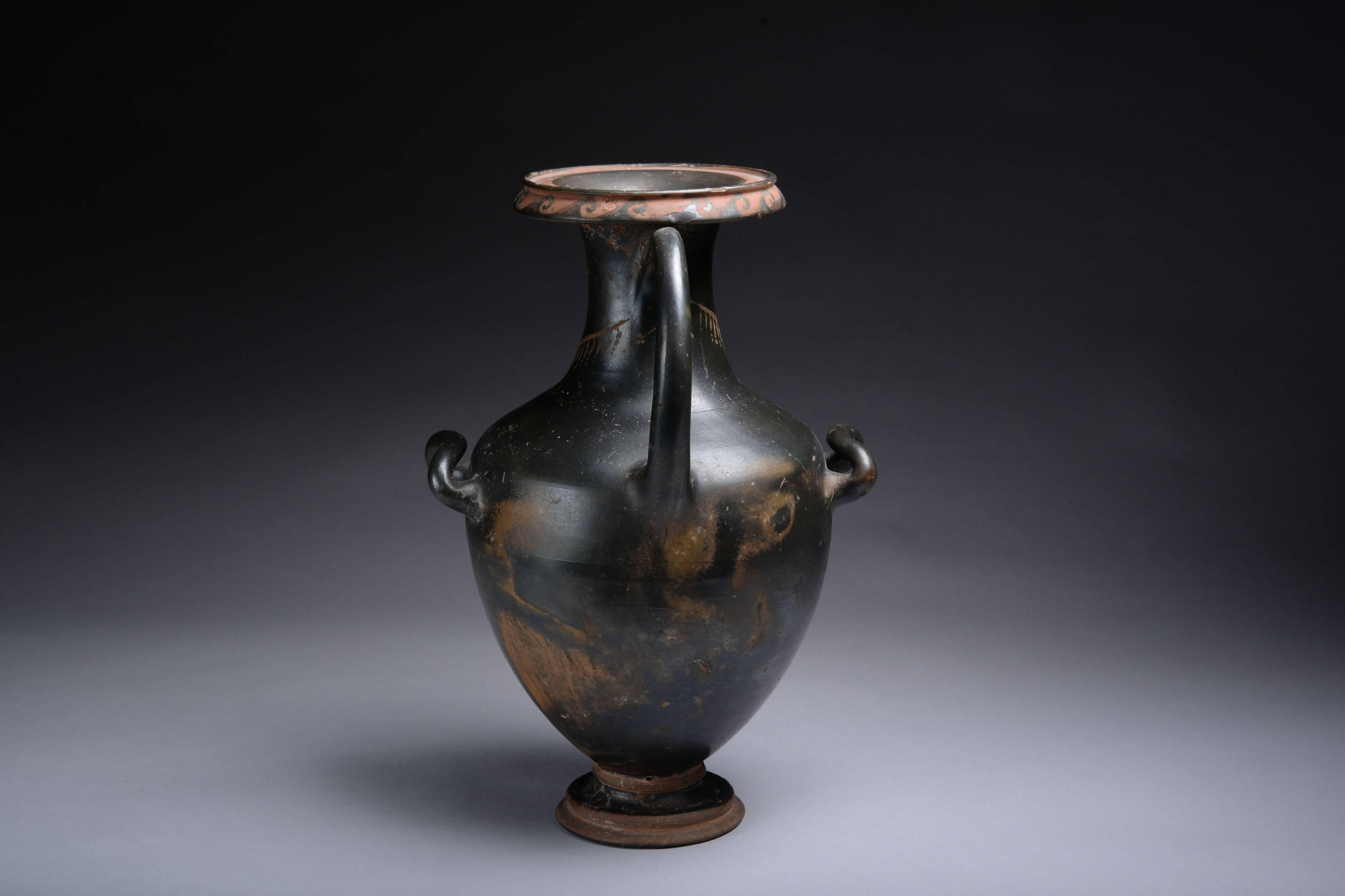 A well provenanced, large, elegant ancient Greek blackware hydria, dating to the 4th century BC.
 
The piece stands on a circular base, rising into an acorn shaped body, cylindrical neck and splayed mouth, a large loop handle arching from the neck
