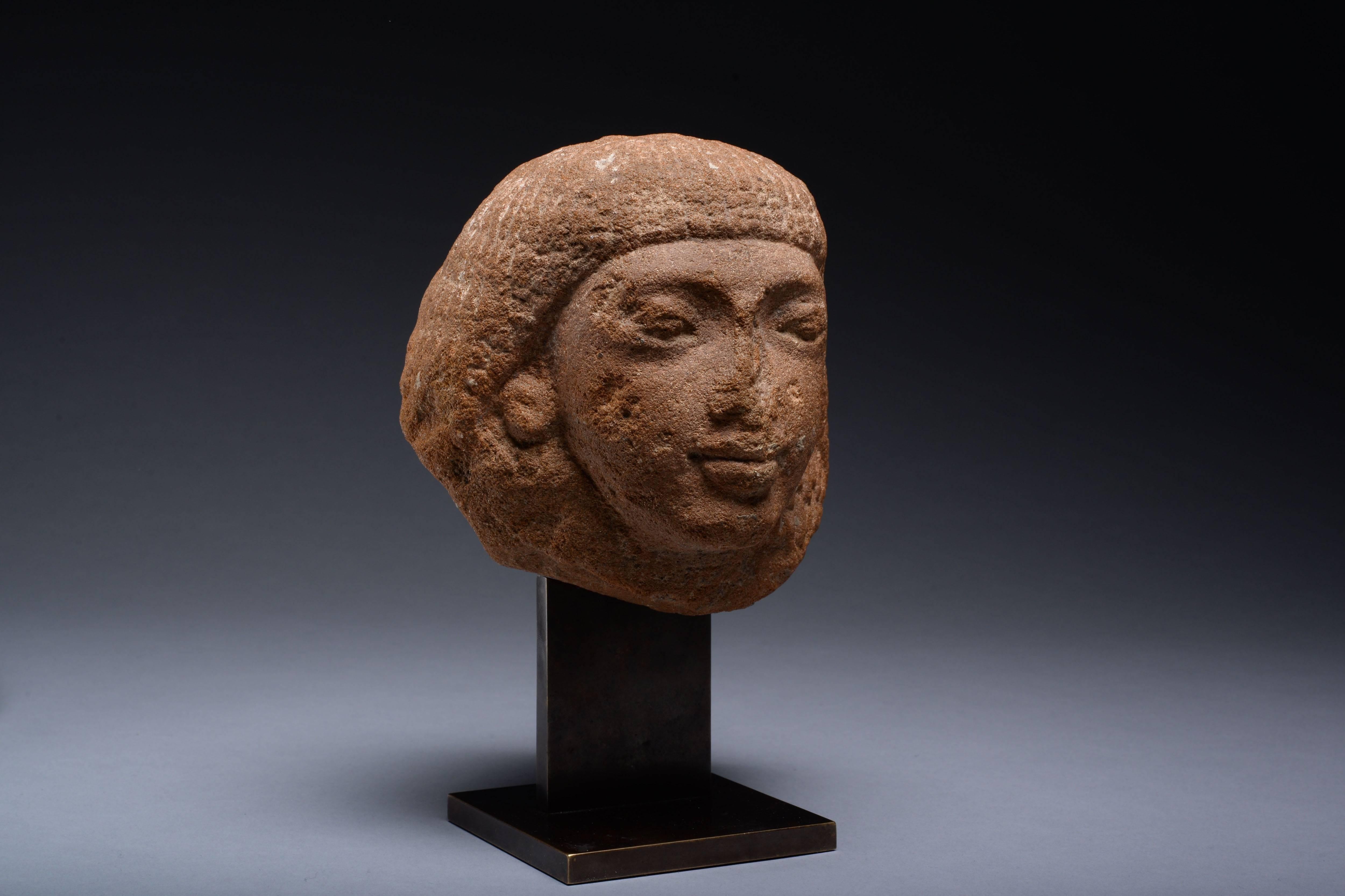 A rare ancient Egyptian quartzite head of an official, dating to the late 18th-early 19th Dynasty, circa 1320-1280 BC.

Carved from a block of quartzite, depicting a man wearing a double wig made from thick strands of wavy locks, the earlobes