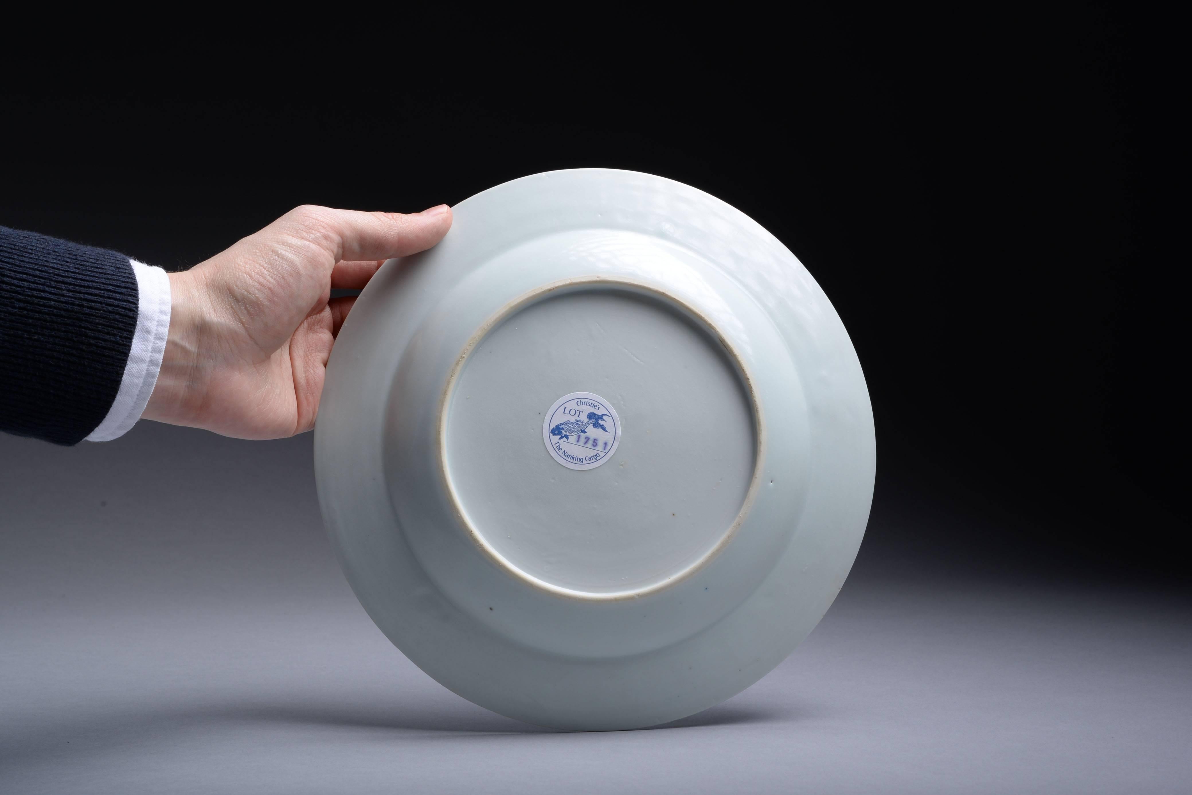 A perfectly preserved, vibrant, Chinese blue on white porcelain dinner plate, dating to approximately 1750 and salvaged from the famous Nanking cargo - an officially recorded piece with Christie's sticker and inventory number.


The centre of the