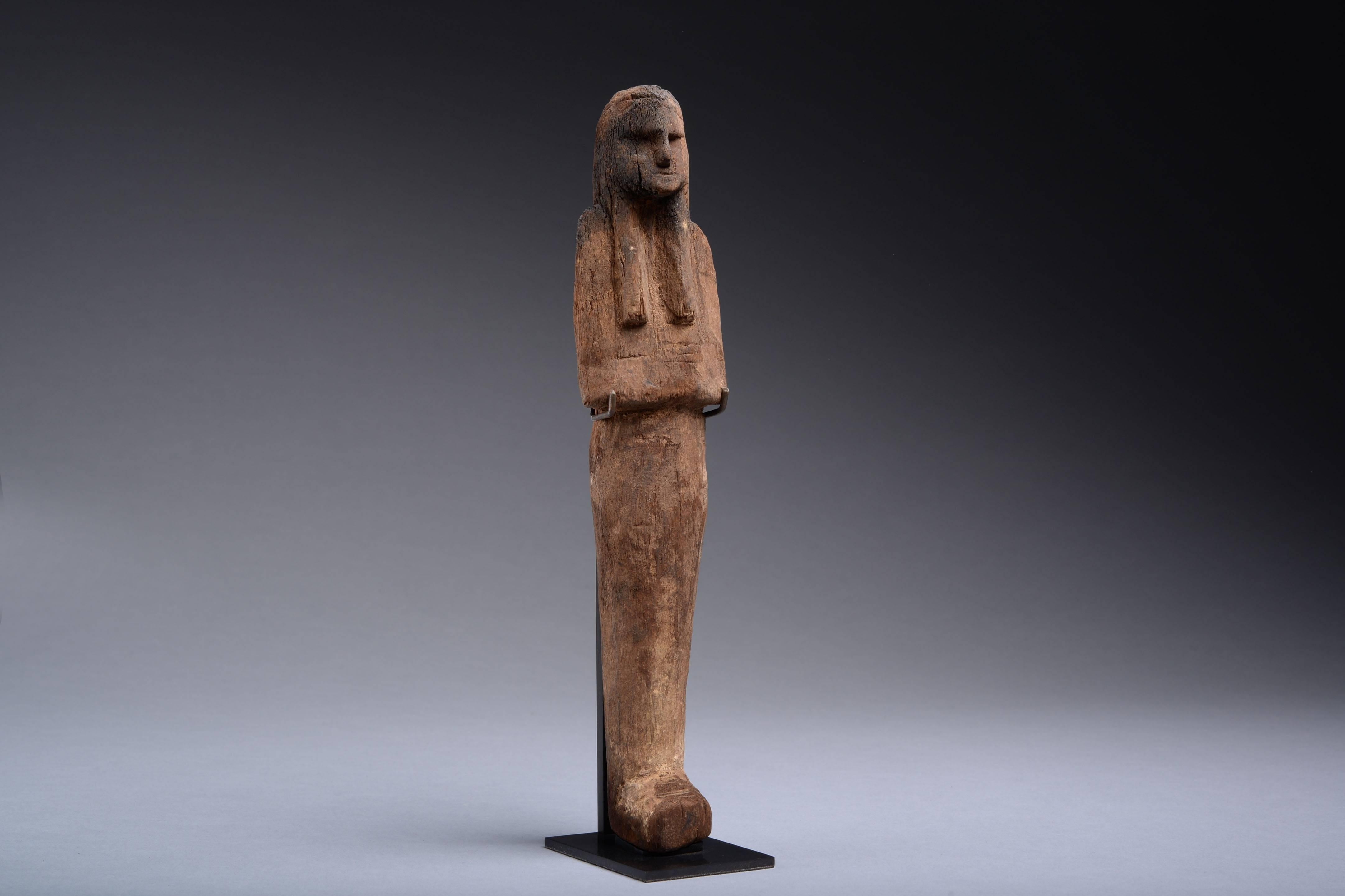 A striking ancient Egyptian wooden shabti dating to the New Kingdom, Ramesside period, 20th Dynasty, circa 1187-1064 BC.

The figure is depicted mummiform, with long slender body, tripartite wig and folded arms.

The ancient Egyptians believed