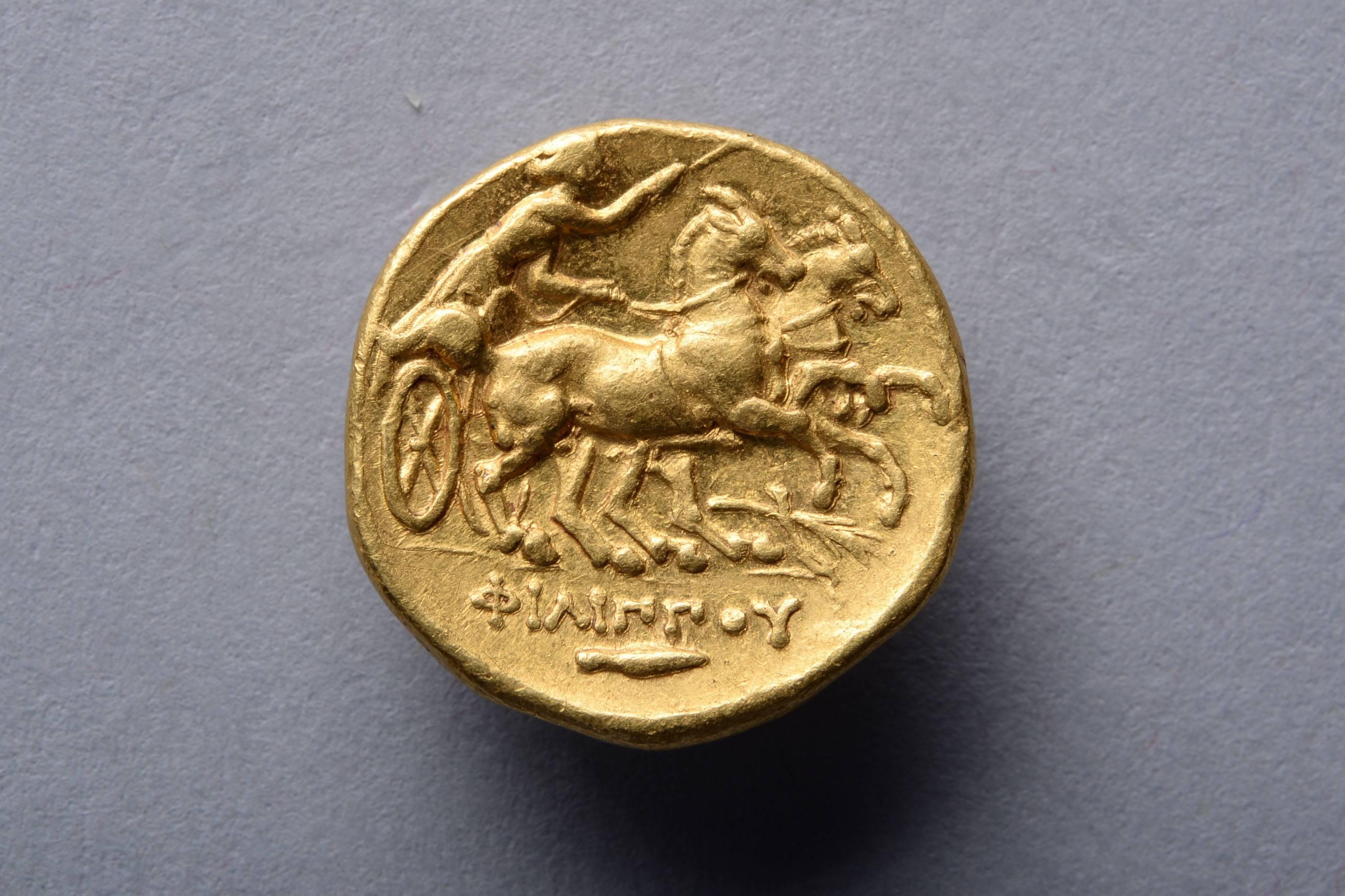 A gold stater issued in the name of King Philip II of Macedon, father of Alexander the Great. Minted in Teos, circa 323-316 BC. 

The obverse with a fine style portrait of Apollo, wide eyed, his lip slightly curled, a laurel wreath running through