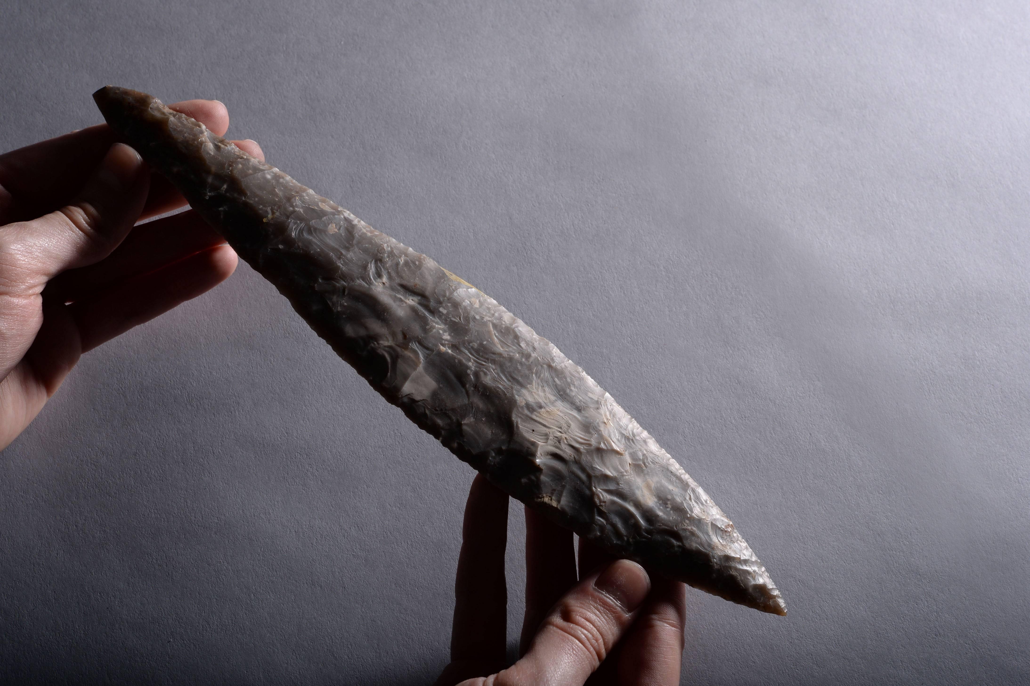 A large Neolithic flint dagger from Scandinavia, dating to circa 2500 BC.

Pressure flaked from a piece of light grey flint with white inclusions, the blade is leaf shaped and of near perfect symmetrical form.

As the societies of prehistoric