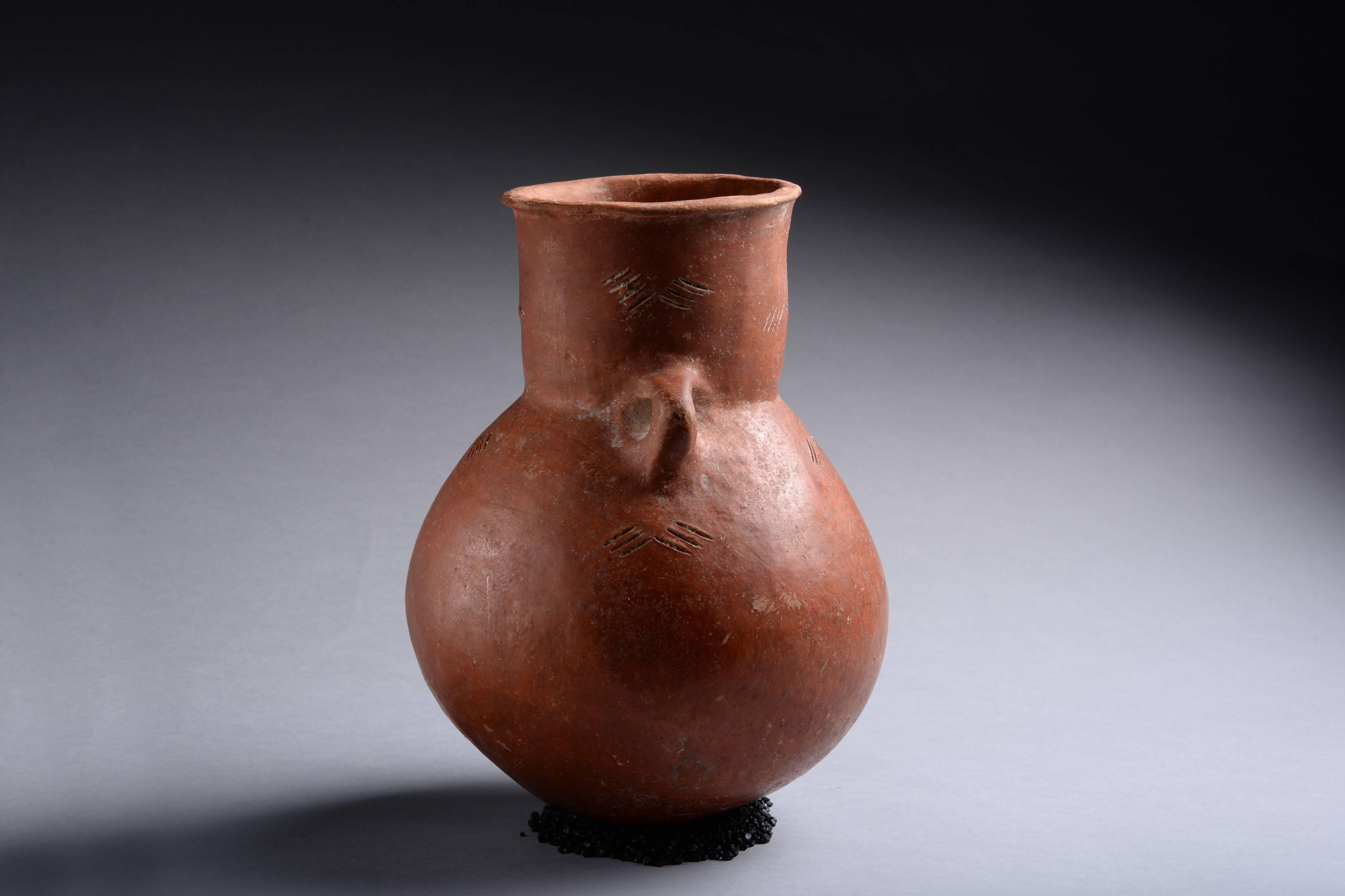 A large red polished ware Cypriot amphora, originally from the collection of General Luigi Palma di Cesnola (1832-1904). Dating to the early Bronze Age, circa 2700 - 1900 BC. 

With rounded, globular body and cylindrical neck and twin angular