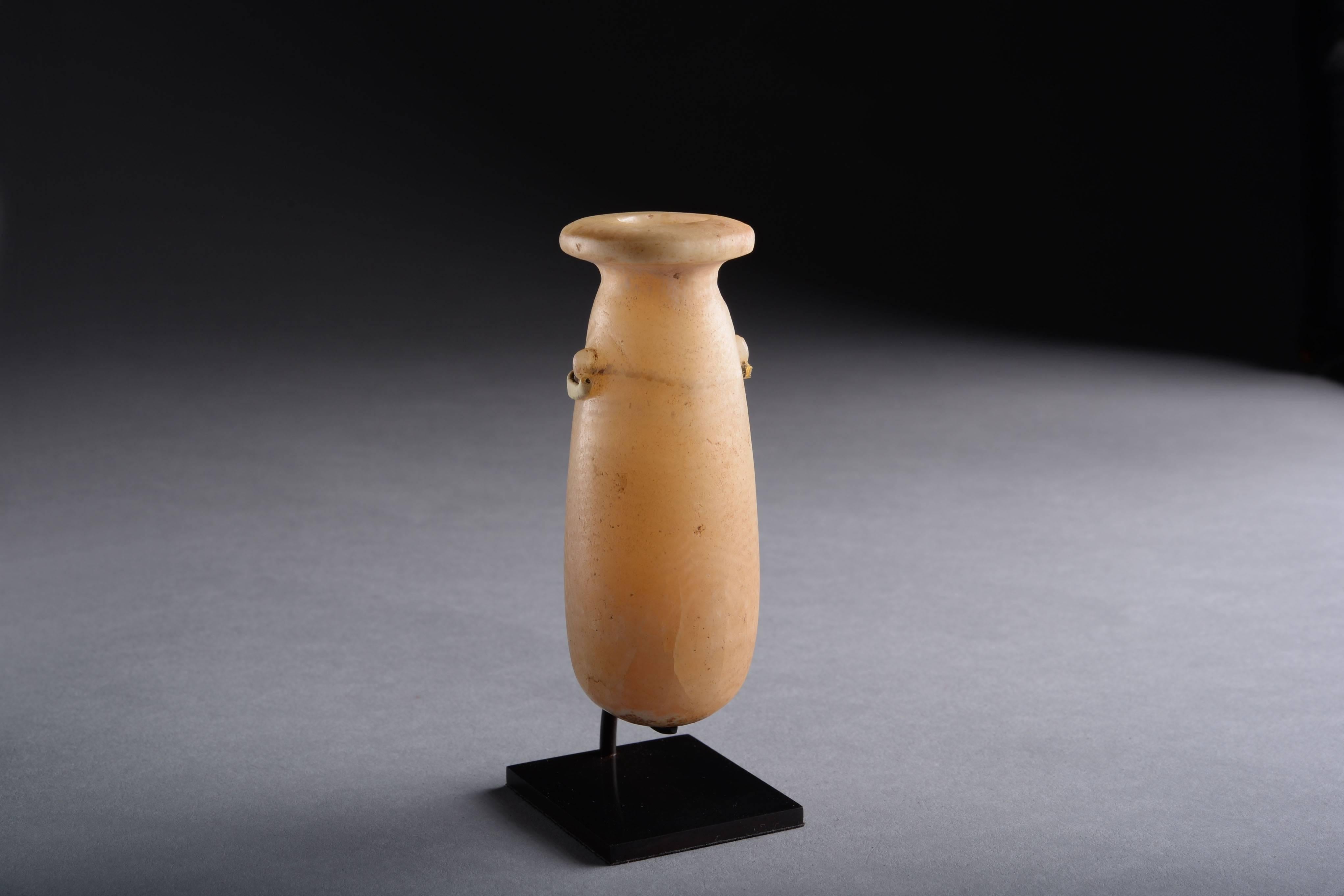 An ancient Egyptian scent bottle or alabastron, dating to the late period, 664–332 BC.

A refined piece of Egyptian stone-working, composed of veined alabaster; the ovoid vessel with round base, short neck, disc rim and twin lug handles.

This