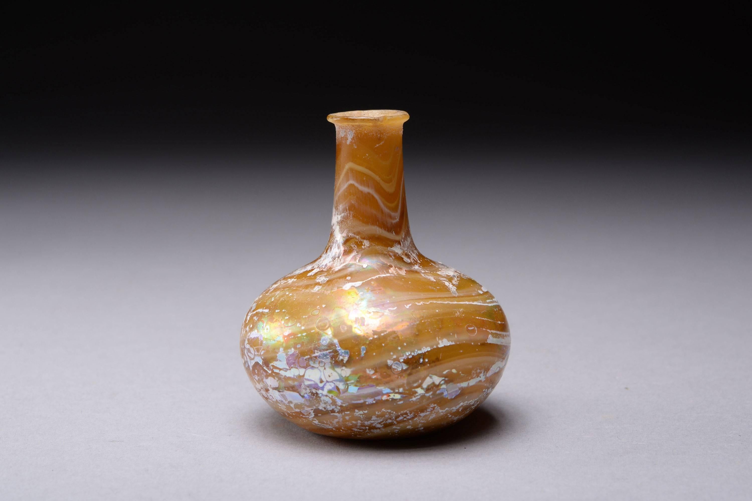A stunning ancient Roman marbled glass bottle, dating to the early to mid-1st century AD.

This exquisite little bottle is beautifully composed, the elegant neck and squat body melt seamlessly together to form a vessel of pure elegance. The