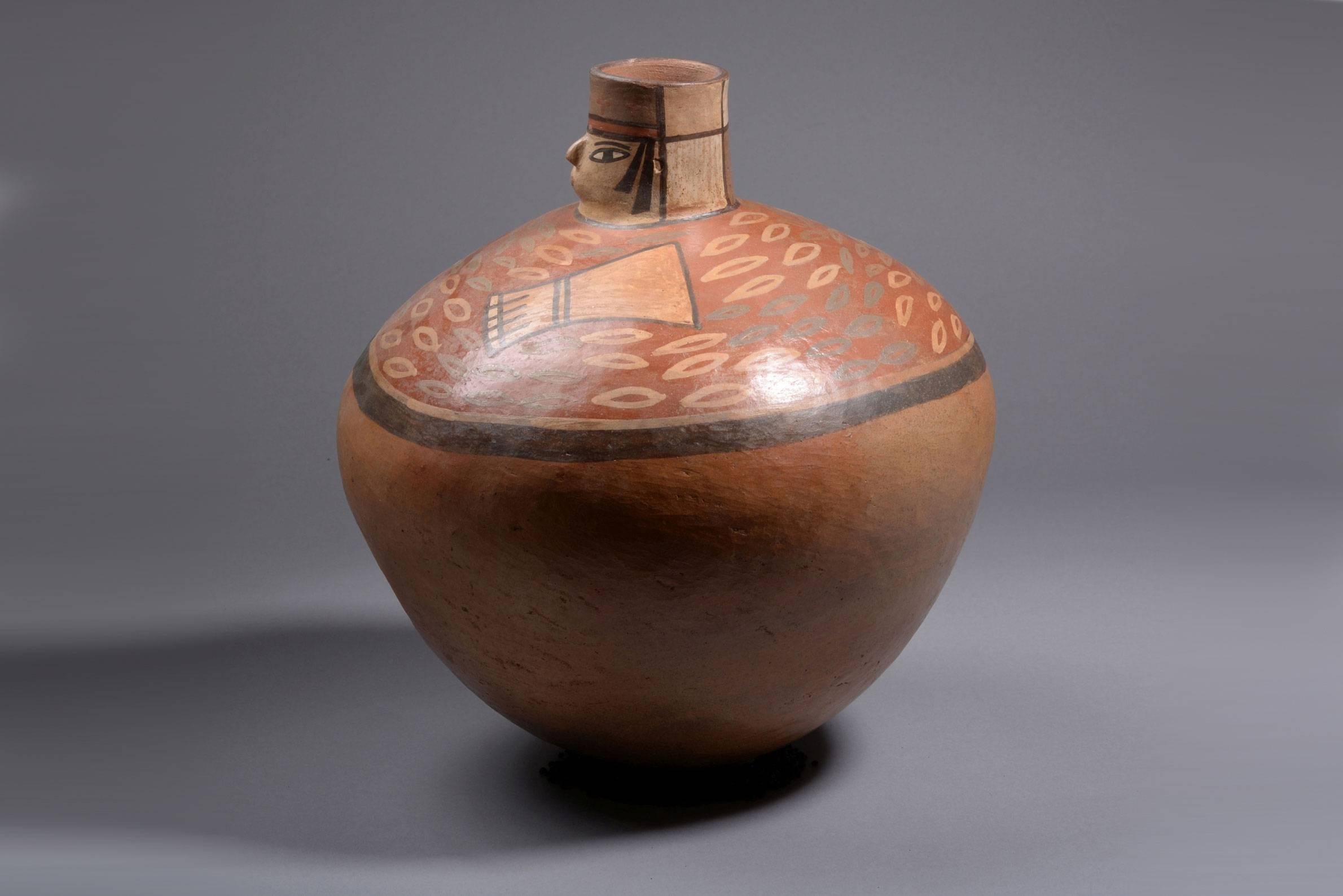 A well provenanced, very large, artistic and vibrant ancient Peruvian Earthenware jug from the Nazca culture, dating to approximately 250 - 540 A.D.

The large ovoid vessel in the form of a rotund hunter. The piece with rounded base, globular body
