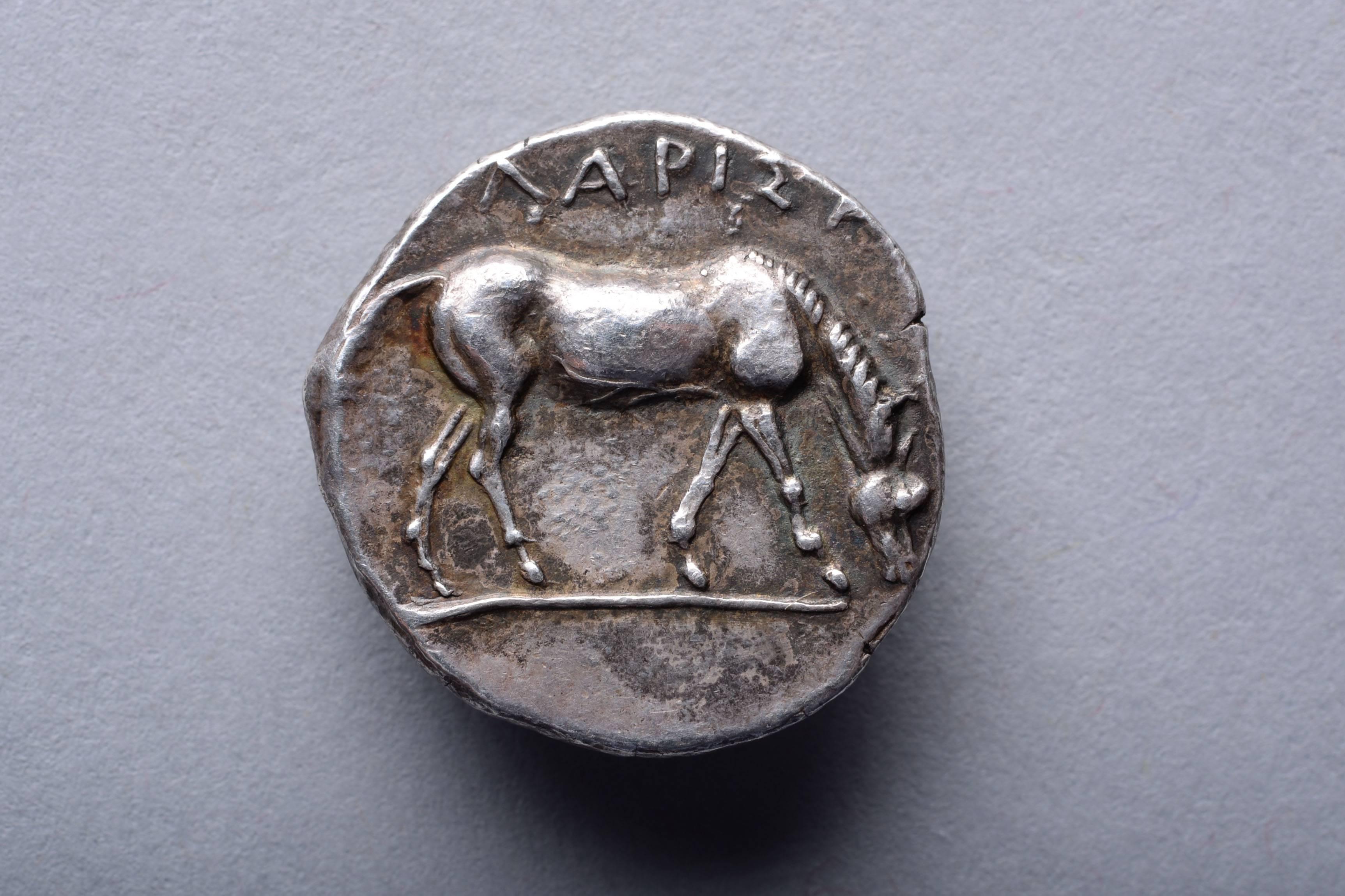 A silver drachm from the city of Larissa, Thessaly, circa 400 - 380 BC.

The obverse with the head of the eponymous nymph, Larissa. Depicted in three quarter profile, framed by her wind swept hair.

The reverse with a muscular horse, shown