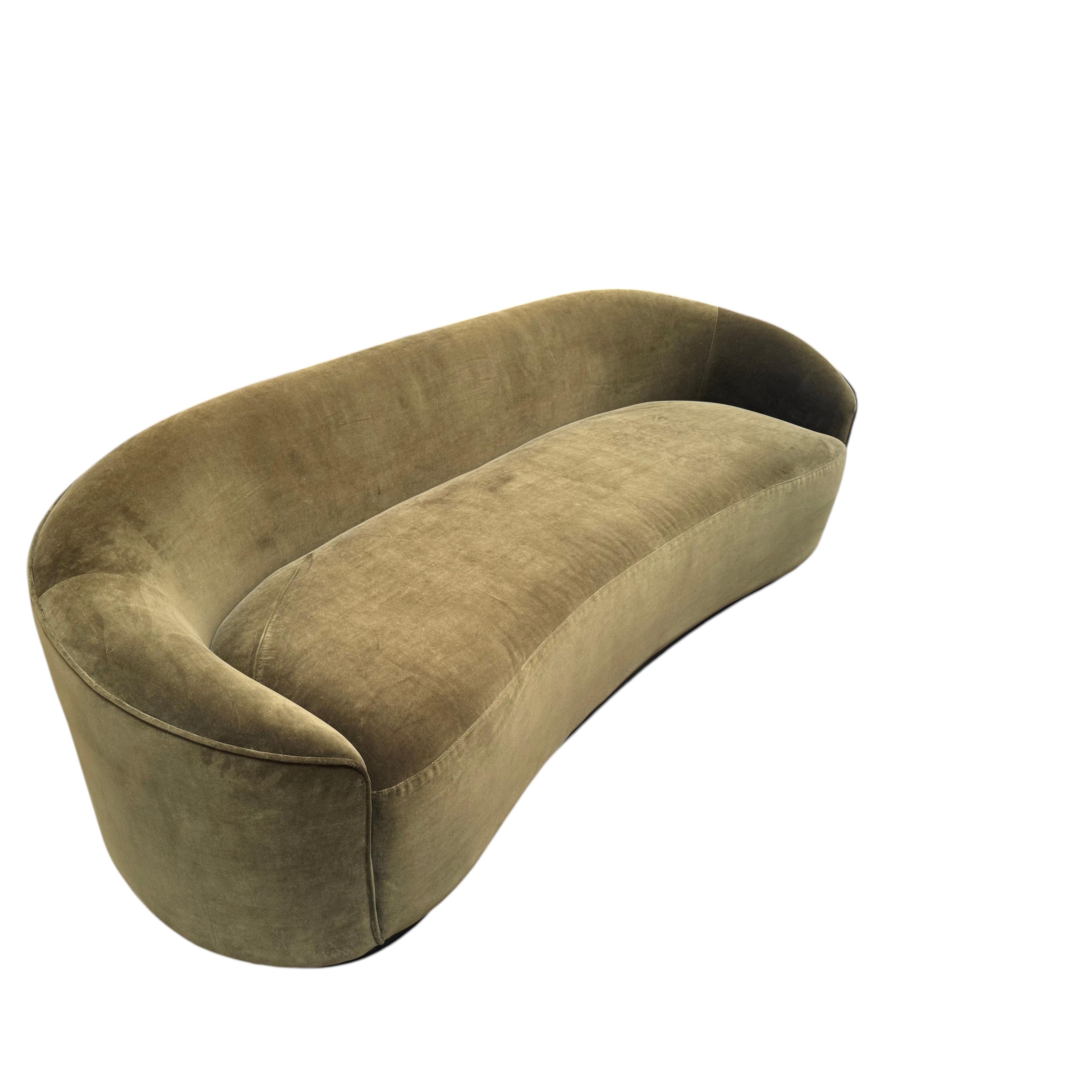 Geschwungenes Sofa aus moosgrünem Samt; stilvoll und bequem