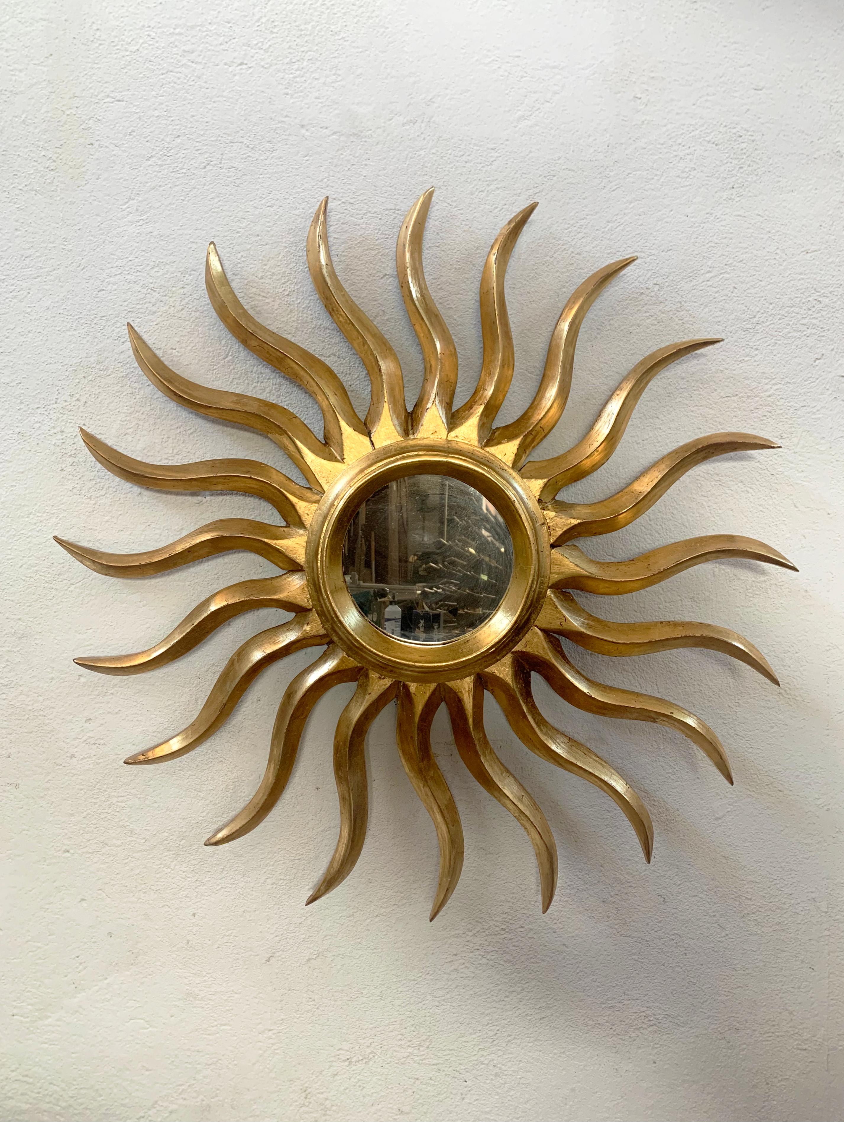 Handgefertigter goldener Sonnenschliffspiegel im Vintage-Stil. Besteht aus einer einzigartigen Ebene von zwanzig gebogenen, vergoldeten Holzstrahlen. 

Abmessungen: 30,32 in/77cm Durchmesser
Abmessungen des Spiegels: 7,90 in/20cm Durchmesser