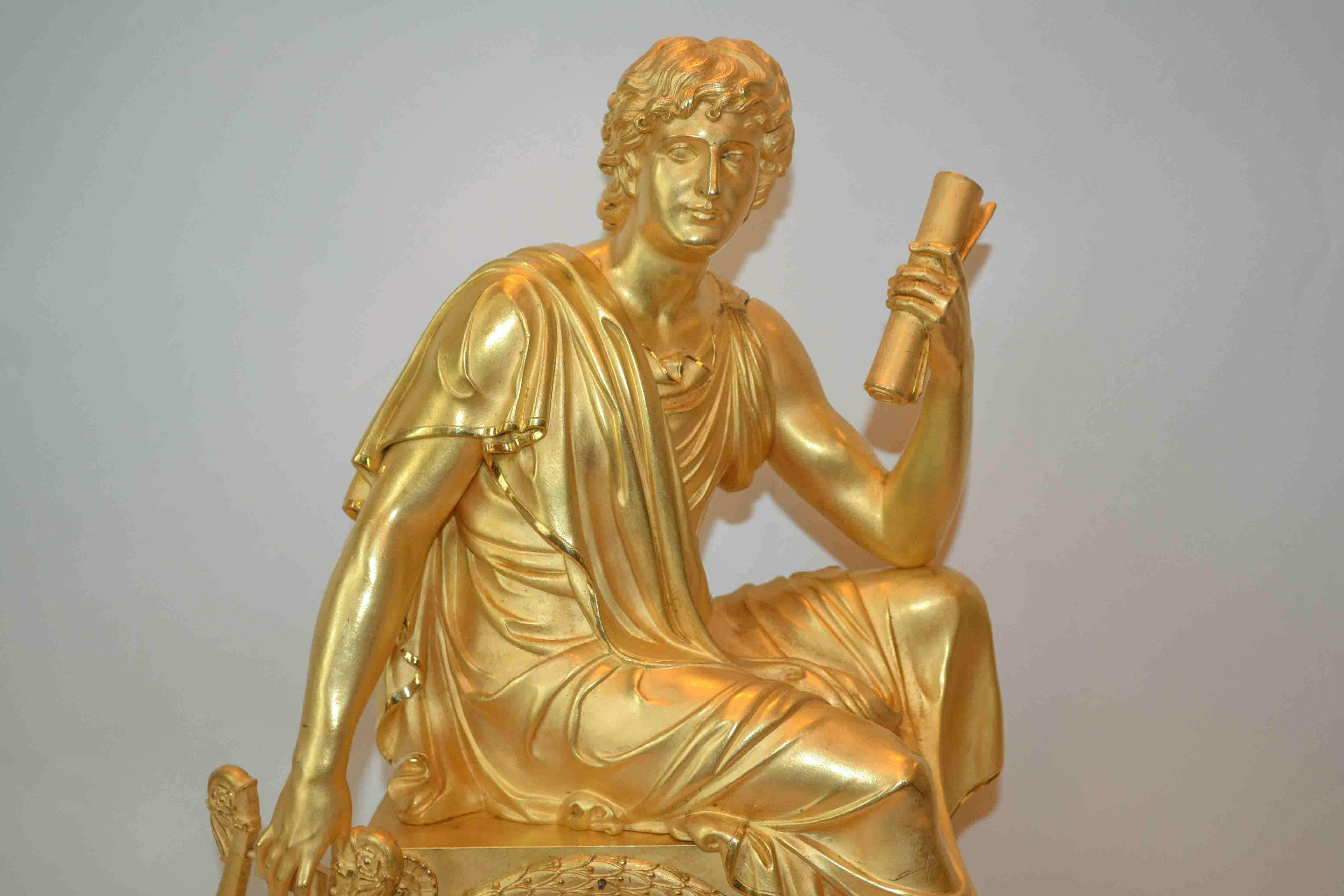 A late, large-scale French Empire clock of a seated, classically draped youth sitting atop the clock case holding a lyre and scroll. The rectangular case is decorated with wreaths and musical instruments, in gilded bronze of the highest quality. The