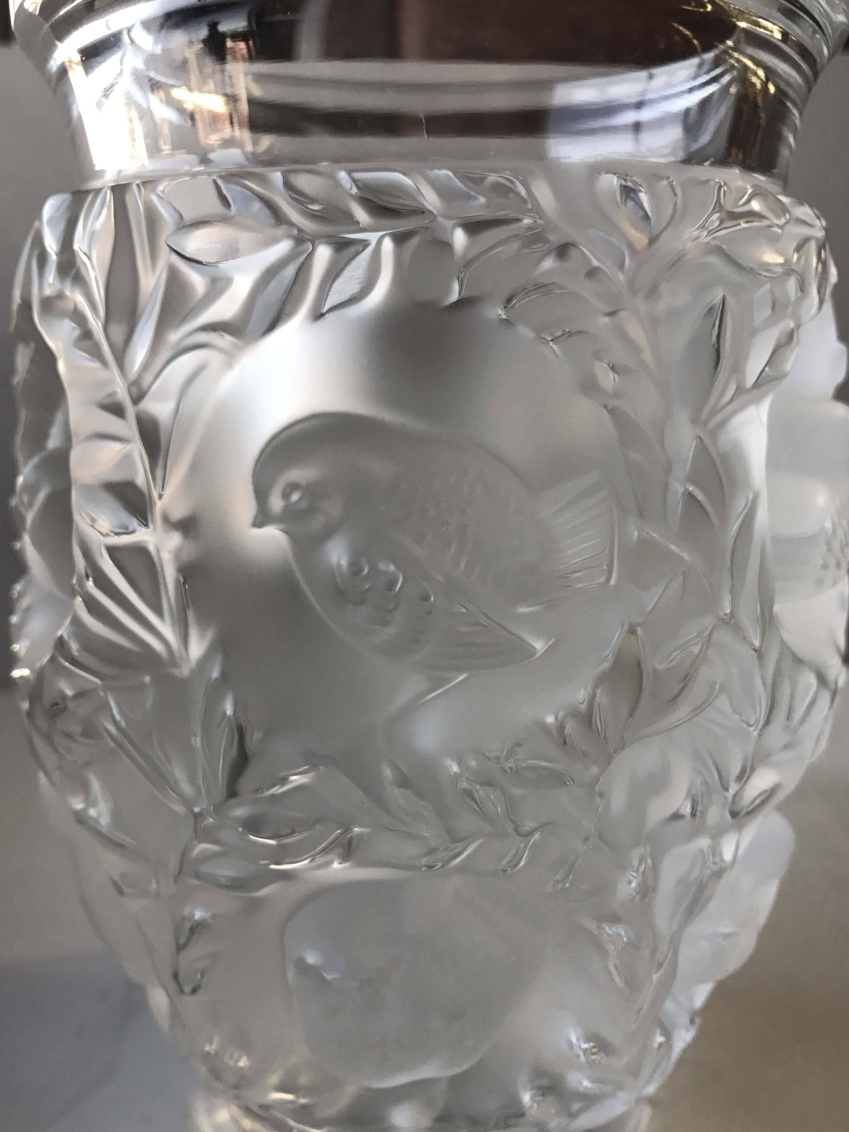 Beautiful vase made in the "Saint Francois" pattern by René Lalique, circa 1930. This gorgeous vase has a flared rim on a tapering cylindrical body of frosted glass and it is relief-decorated with birds, leaves and vines. This pattern