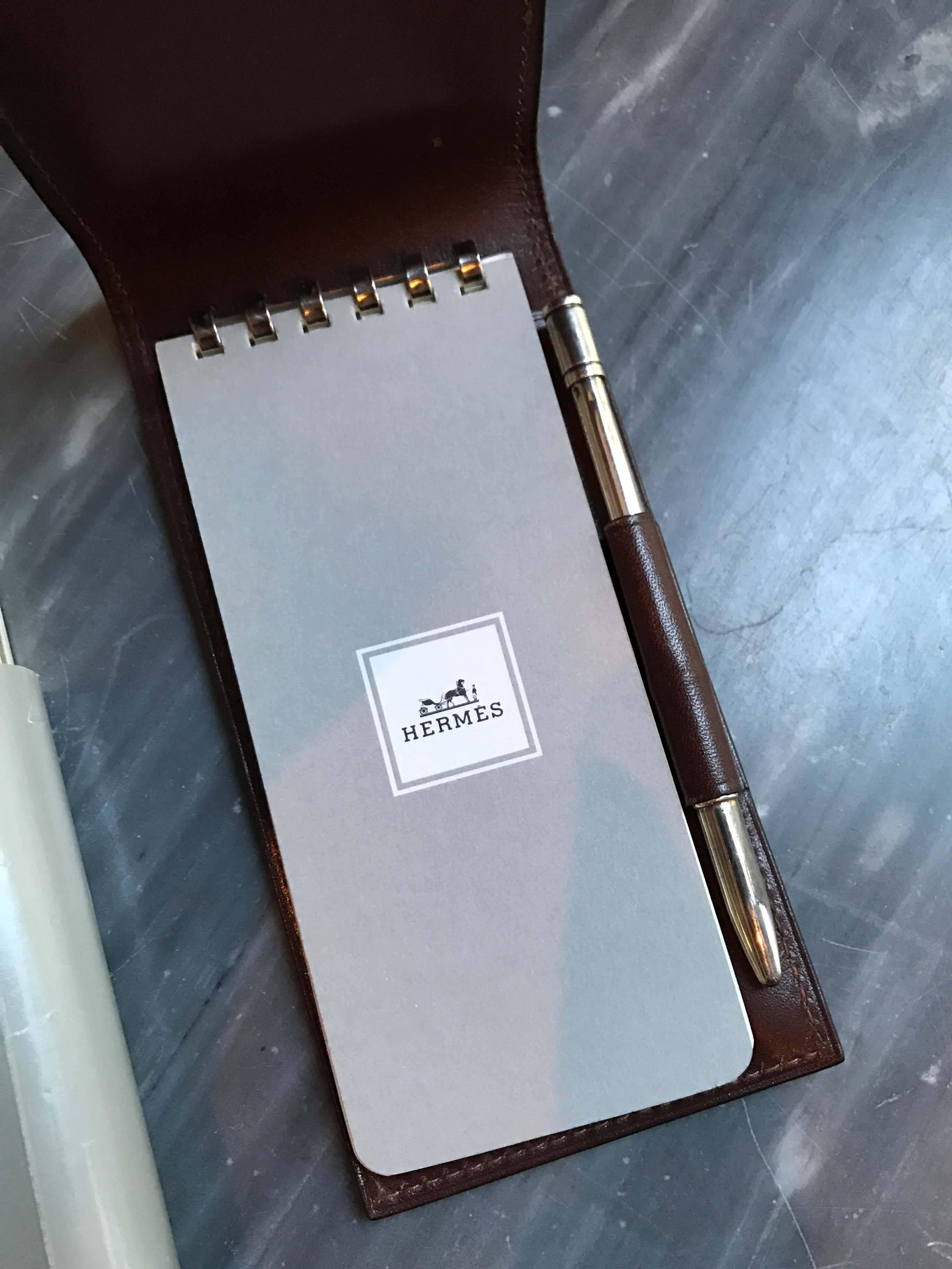 Leather note pad and pen by Hermès with four refills. Good condition with minor wear consistent with light use.
 