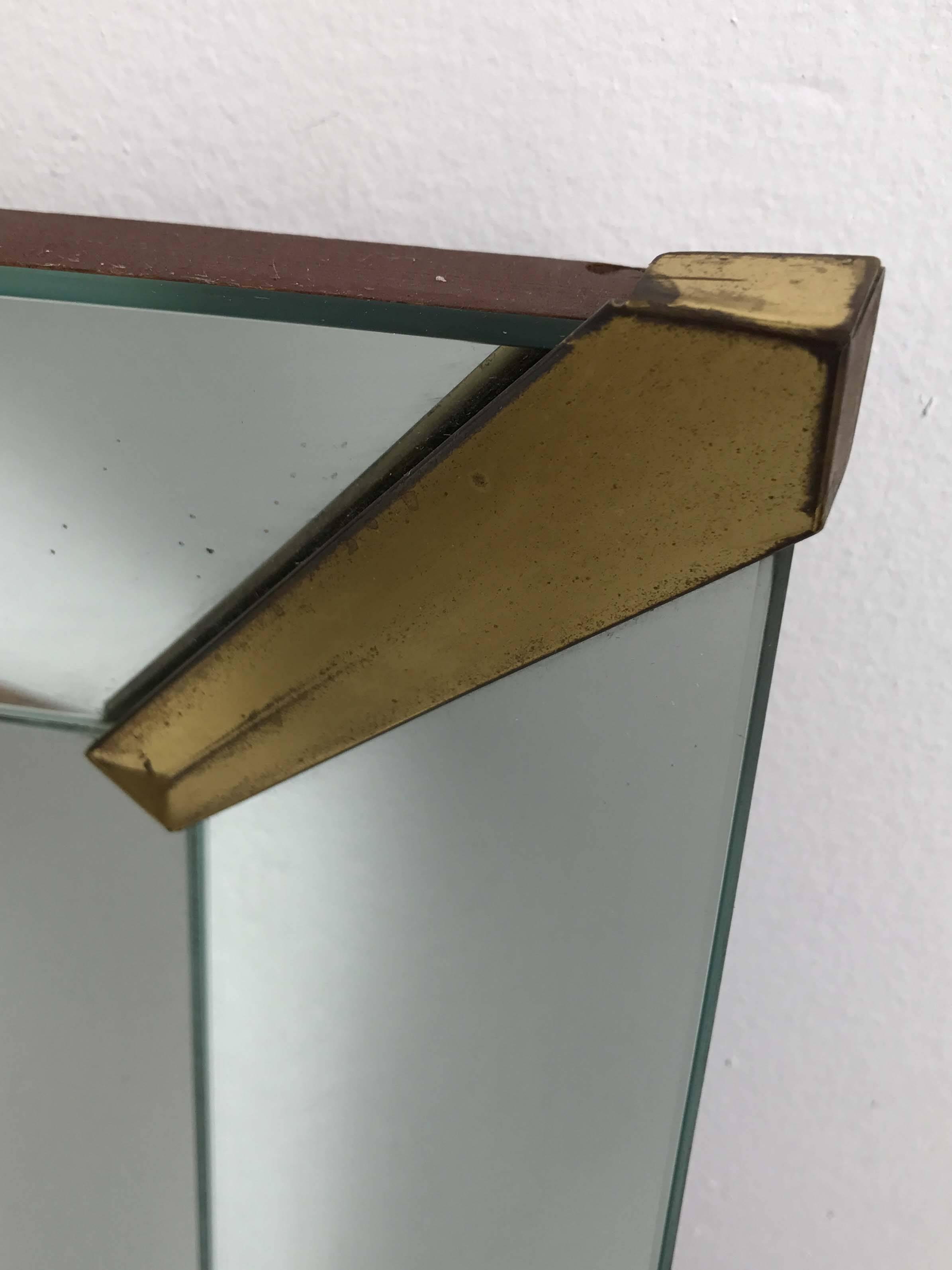 Rectangular mirror with Art Deco inspired brass mounts. Mirrored frame. Note the patina on mounts and minor wear to mirror consistent with age. 

  