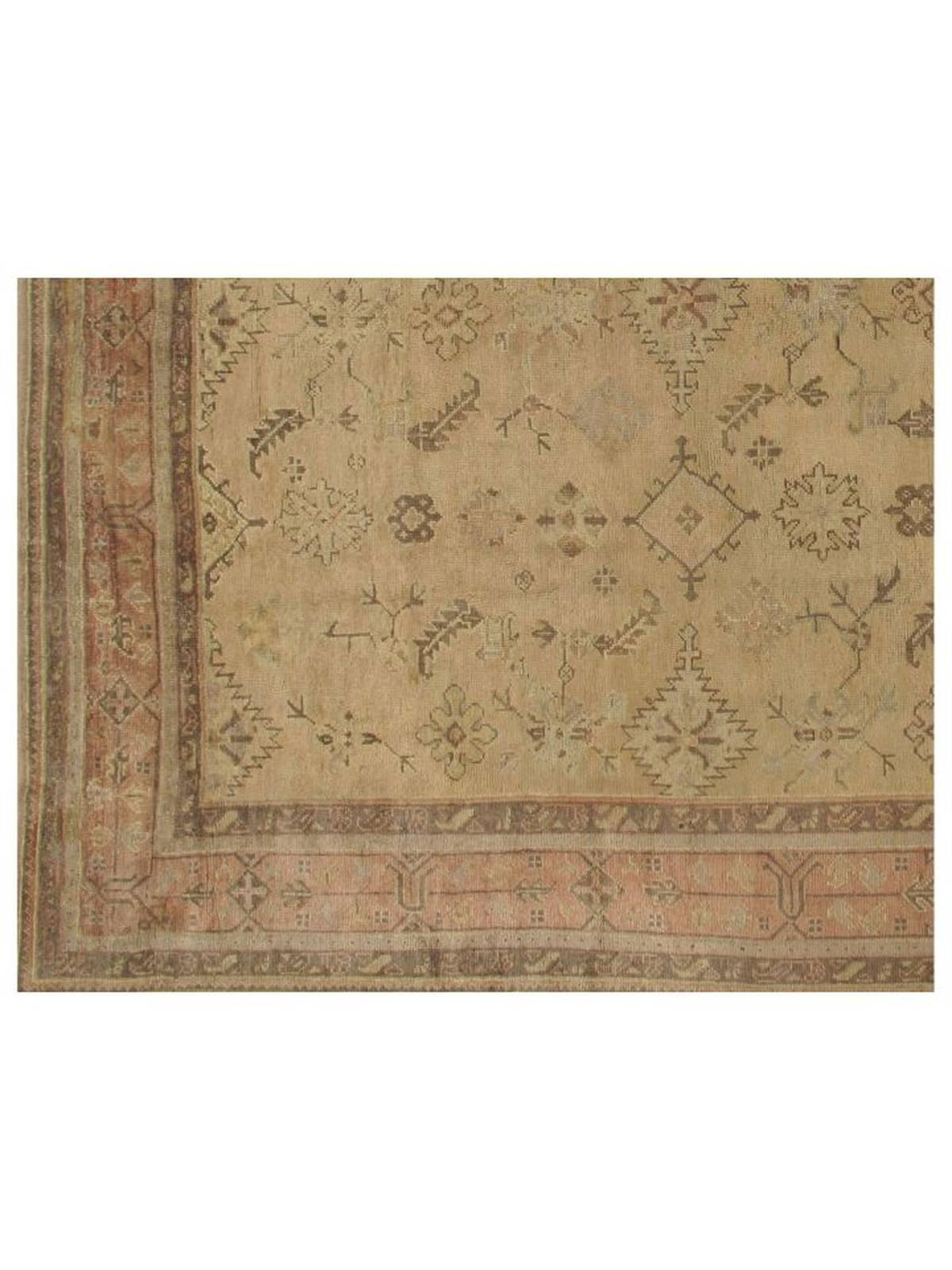Hand-knotted wool Turkish Oushak rug, showcasing traditional motifs surrounded by detailed borders in a harmonious blend of warm hues. Rendered in soft gold, faded coral, taupe, grey and green. Very good condition with minor wear consistent with age