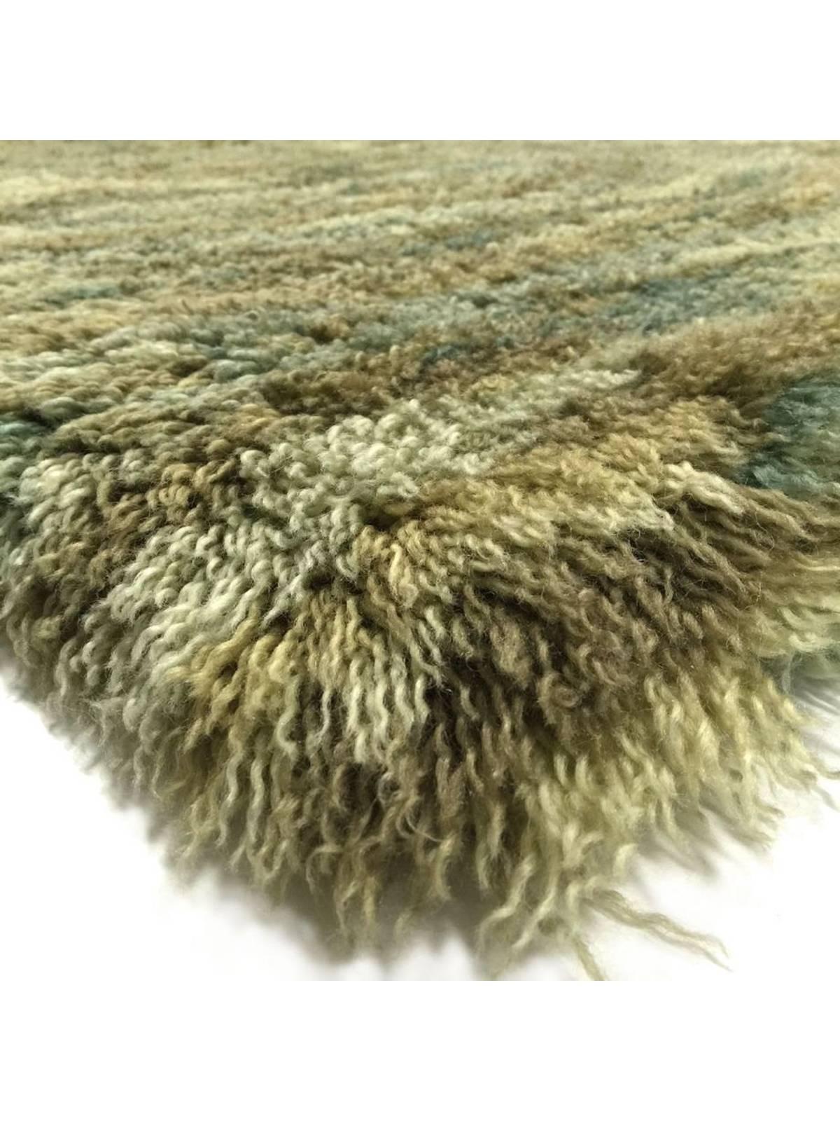A unique blend of Angora and New Zealand wools give this handwoven shag carpet its lustre and softness. A mixture of teal, ivory, green, and tan create a soothing wave movement reminiscent of rippling water, with East Asian vibes.