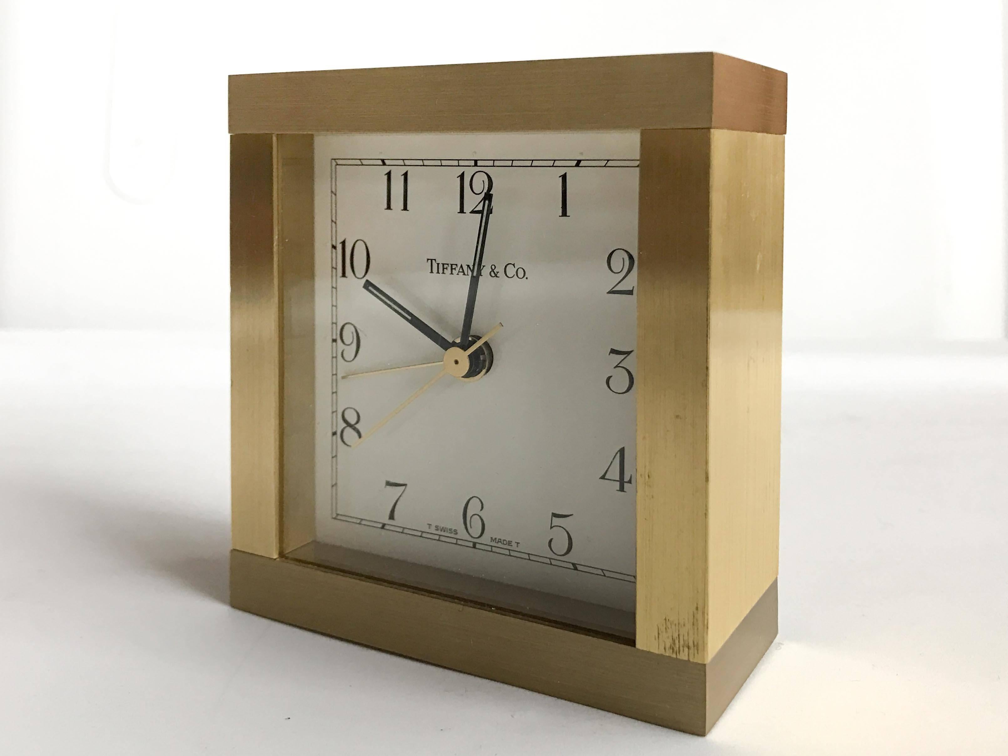 Small square desk clock made of brass and marked Tiffany & Co. Good working condition with minor wear to the case, some burnishing to the top, please see photos.