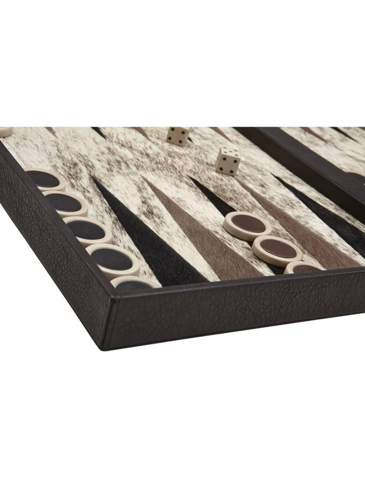 Handmade backgammon set crafted of black leather and grey, caramel and black cowhide. Paired with ceramic chips which are accented on top with mocha cowhide. A functional game and chic accent. Made in France.
  