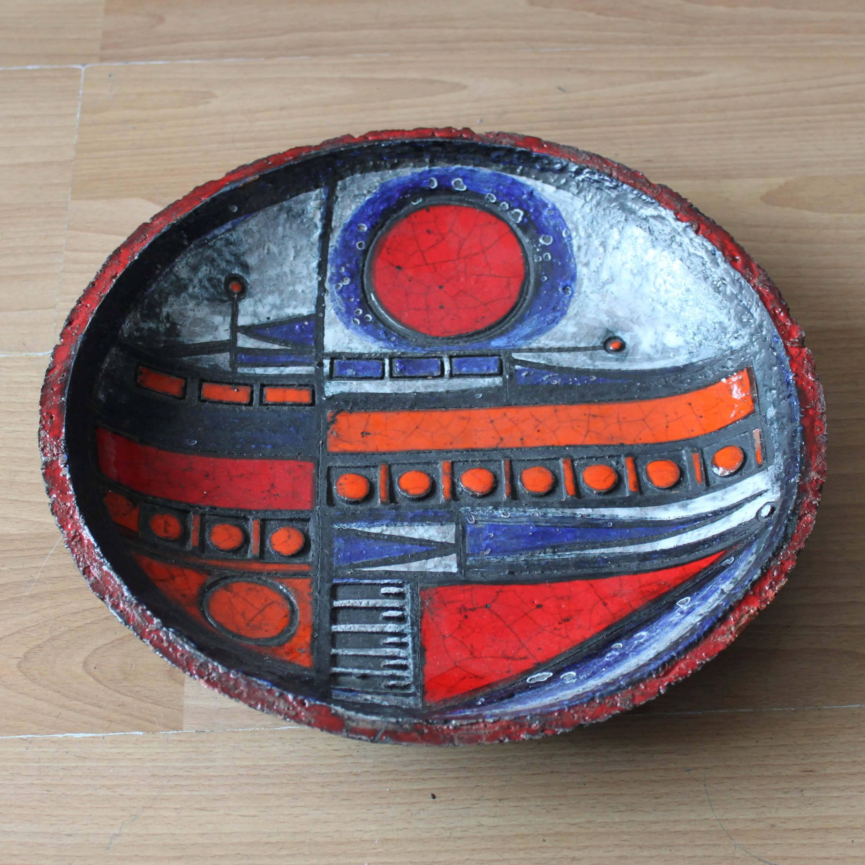 Modernist pottery bowl with colorful geometric pattern. Marked on back with wire hanger for wall hanging. Very good vintage condition.
 