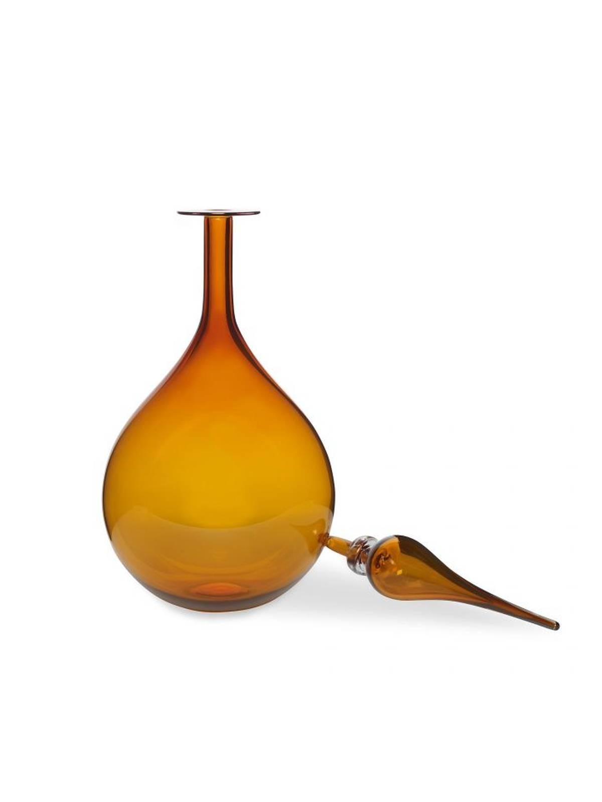 The Petite tear drop decanter by Joe Cariati features a rounded, tear drop shaped body and is detailed with a decorative glass stopper. Inspired by Mid-Century classics, handmade in LA.