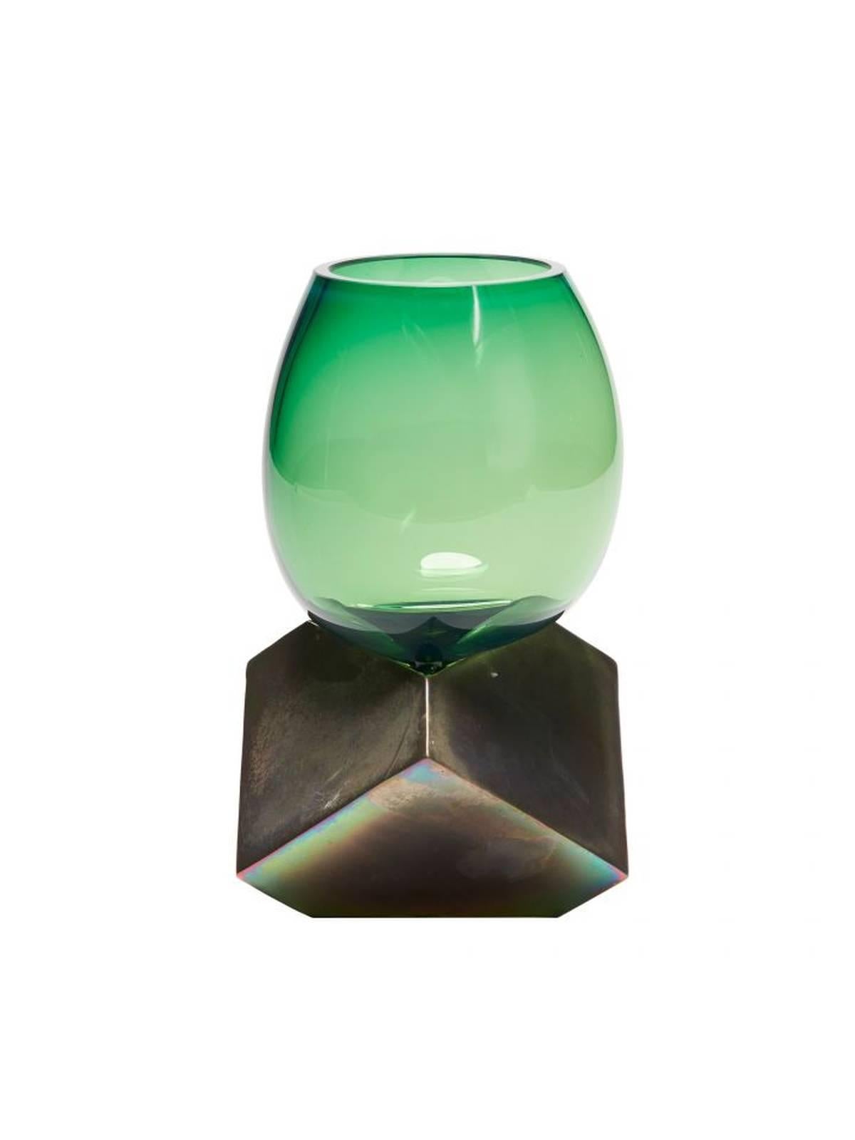 An artisanal green glass vase, blown without a mold. Subtle bubbles are a testament to its handmade origin. Rests on a bronze base. Made to order, each piece slightly unique. Made in France.