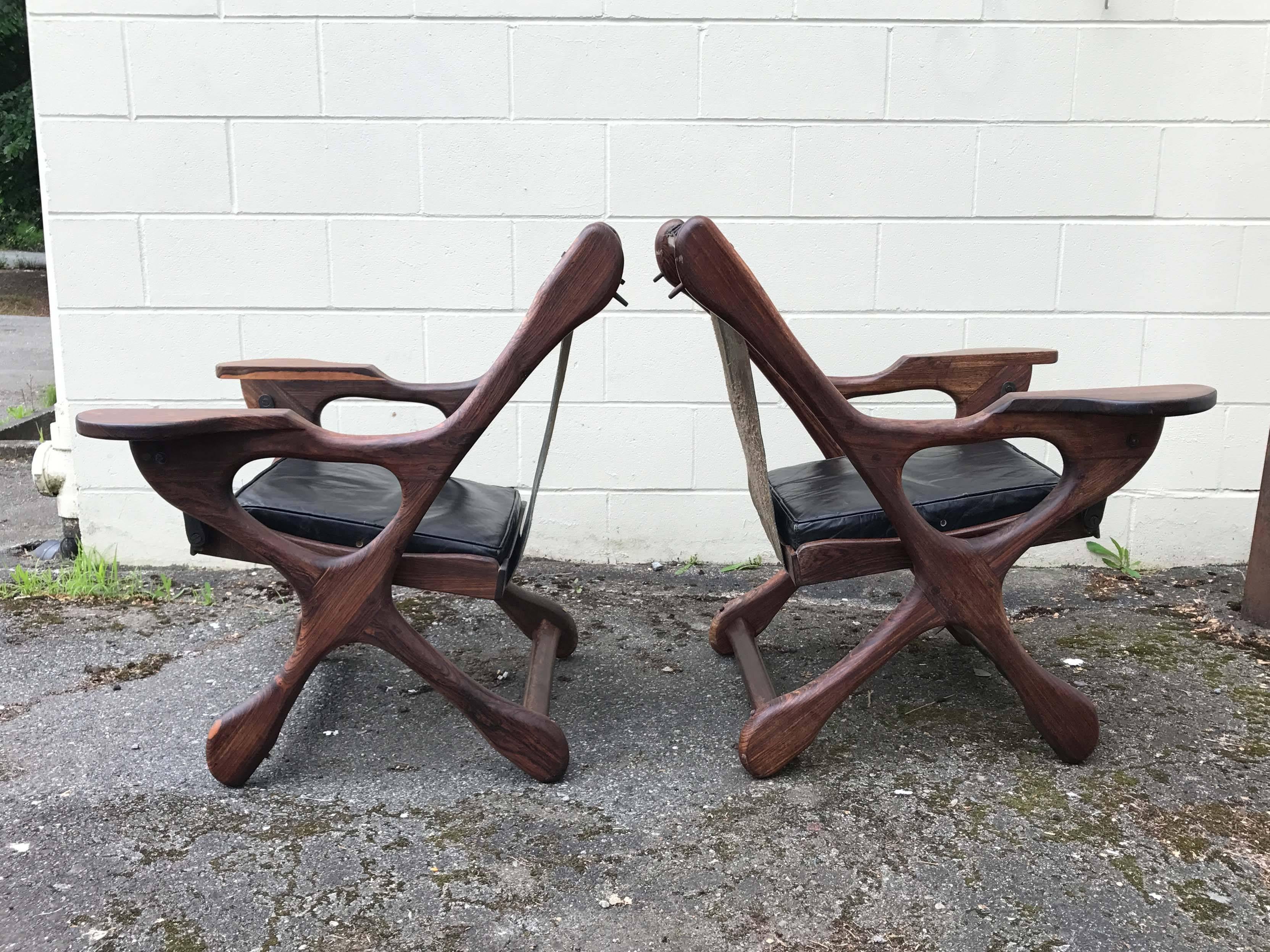 Swinger sling chairs by Don Shoemaker. This iconic chair features doweled joints, handcrafted hardware and original leather upholstery. Some minor repairs and wear consistent with age and use, please see photos.

 