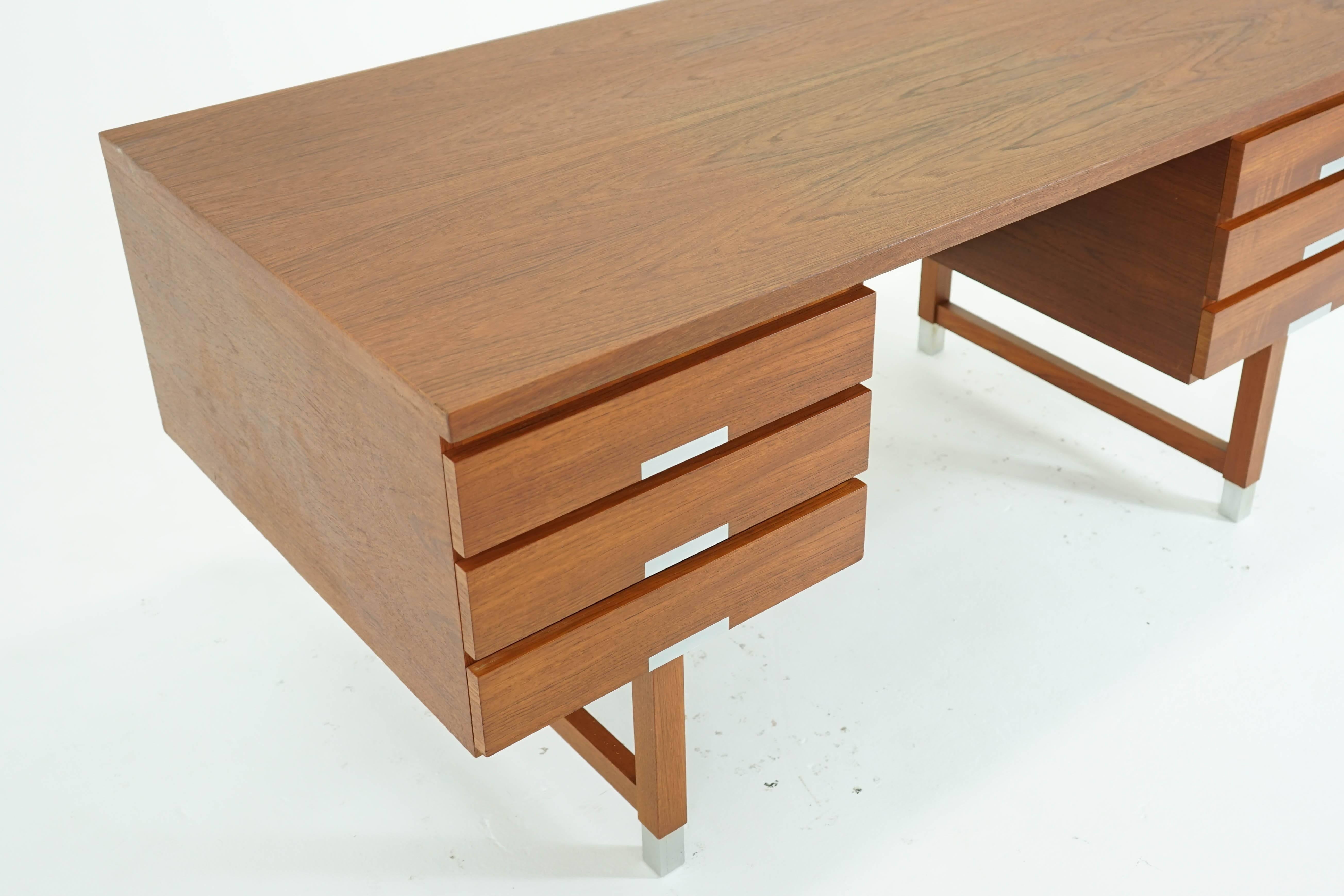 A modern solid teak and veneer desk by Kai Kristiansen. Removable legs with sabots, finished front with shelving/storage for display. Very good original condition.
