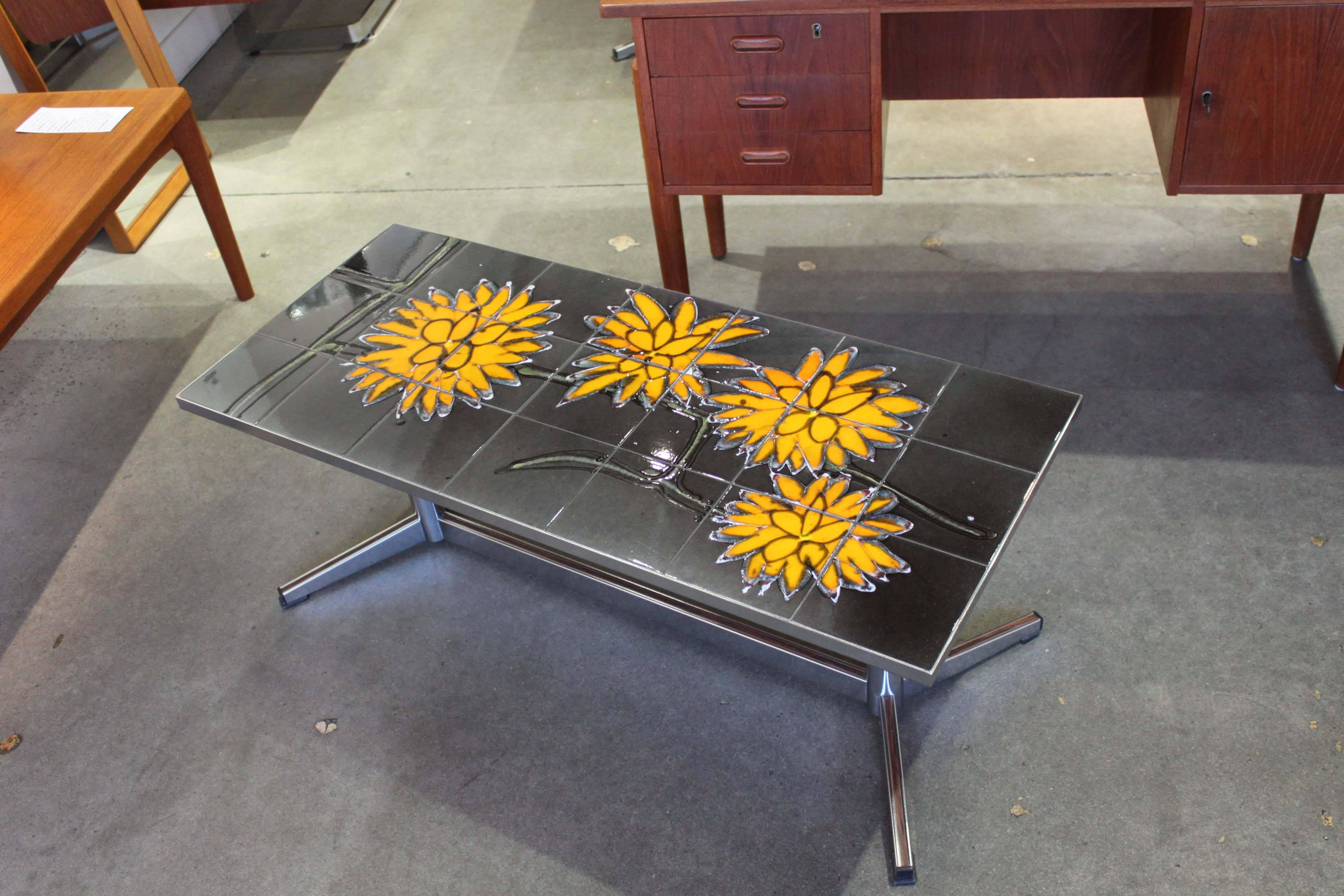 Tiled coffee table with floral motif attributed to Danish maker Adri. Chrome base has woodgrain inserts, in very good original condition.
