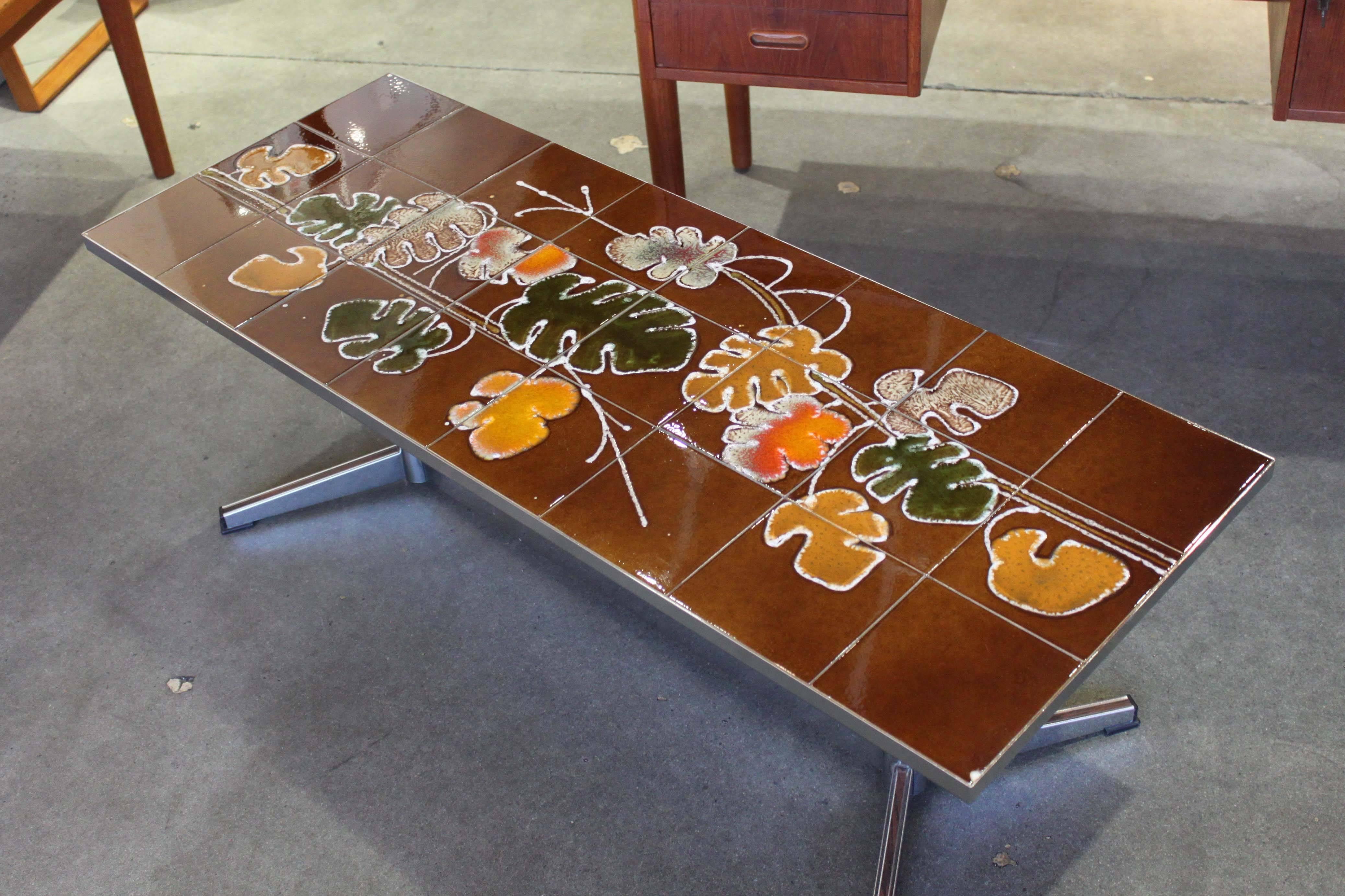 Tiled coffee table with floral motif attributed to Danish maker Adri. Chrome base has wood grain inserts, in very good original condition.