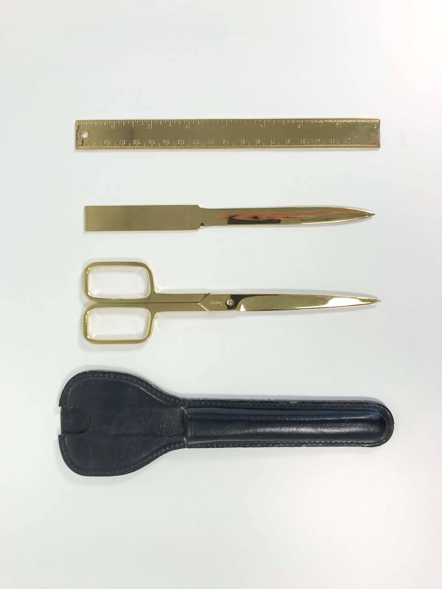 Gold-plated desk set by Asprey includes the following:

1 x Scissors
1 x Letter opener
1 x Ruler
1 x Leather case.

In excellent overall condition with minor wear consistent with regular use.