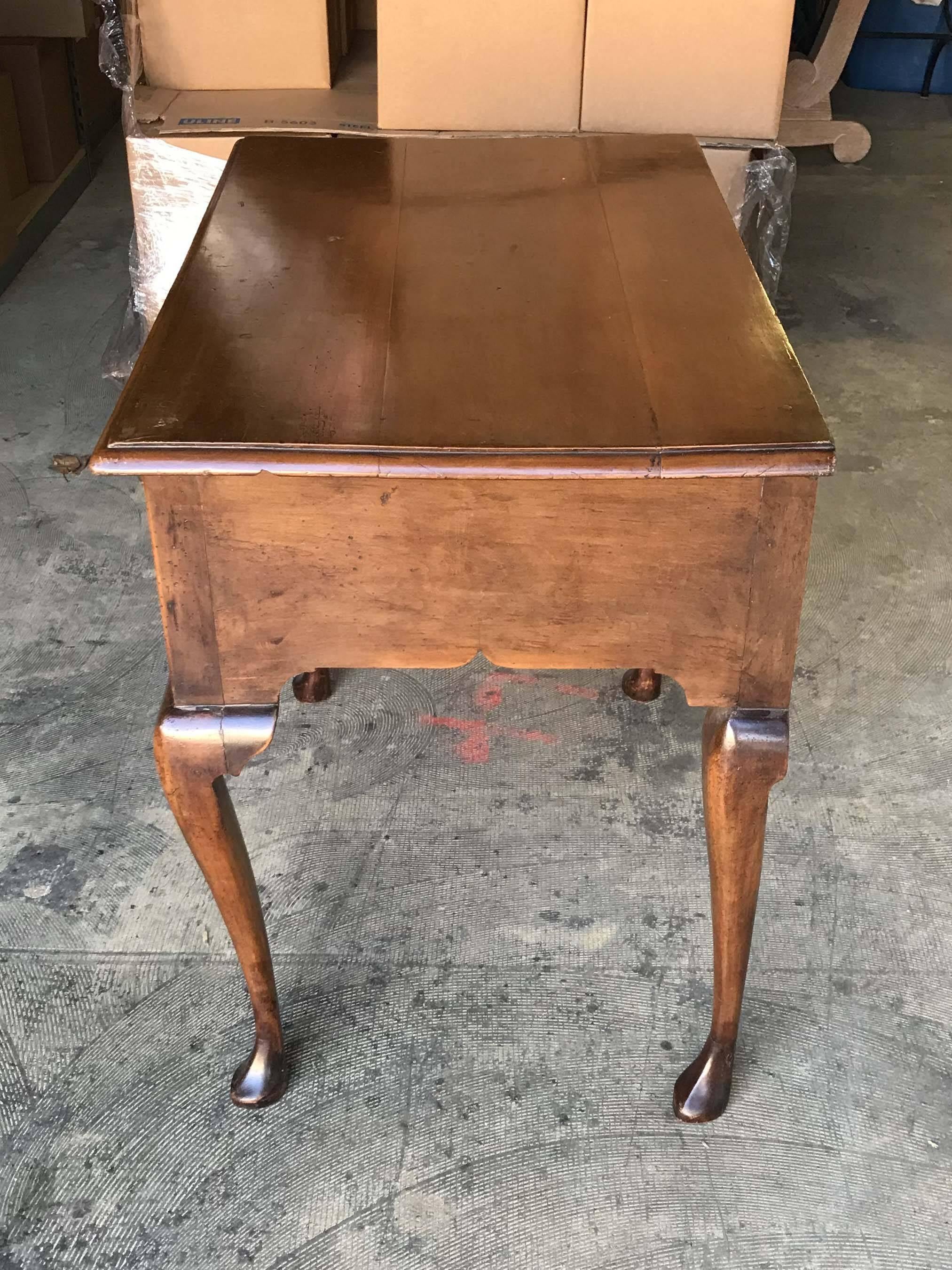 A three-drawer Queen Anne or Georgian-style lowboy with original brass mounts and functioning lock. Very good condition with minor wear consistent with age and use. Please see photos.