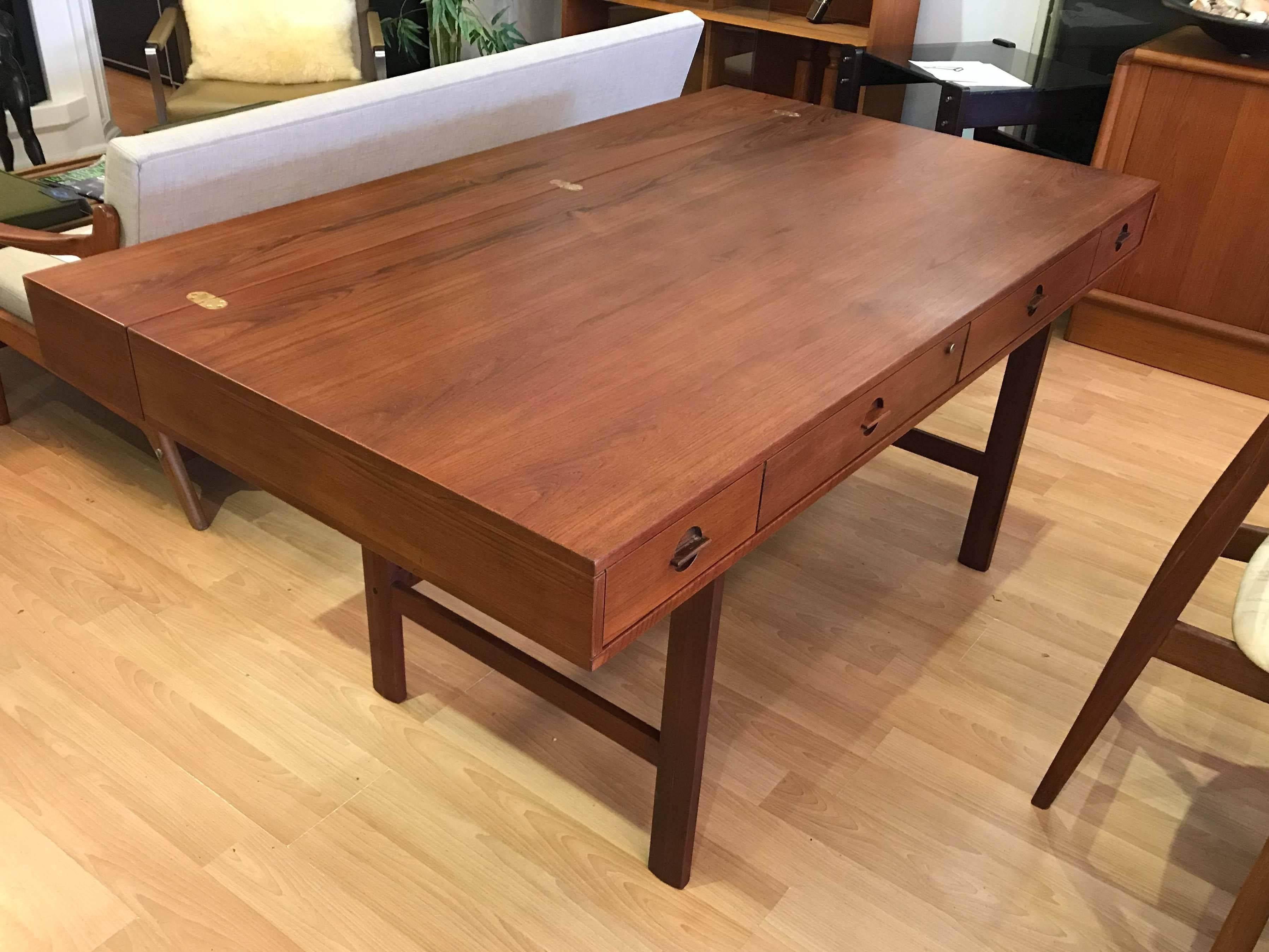 Danish teak flip-top partners desk by Peter Løvig Nielsen. The top has a variety of segmented compartments. The upper section is hinged and flips backward to expand the depth from 29