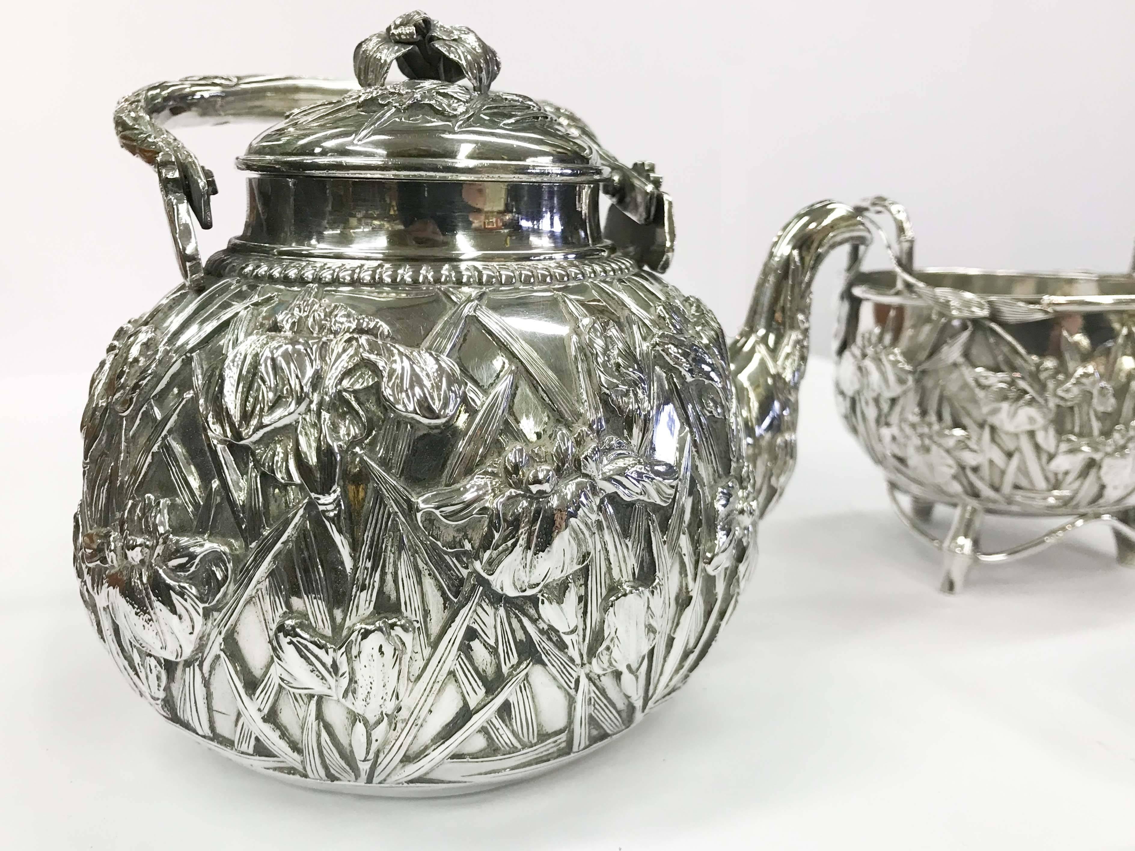 A solid 9.25 sterling silver Japanese repoussé tea set. Includes teapot, sugar bowl and creamer. Very good overall condition, some minor impressions on bottom of vessels consistent with age and use. Total weight 931 grams. 