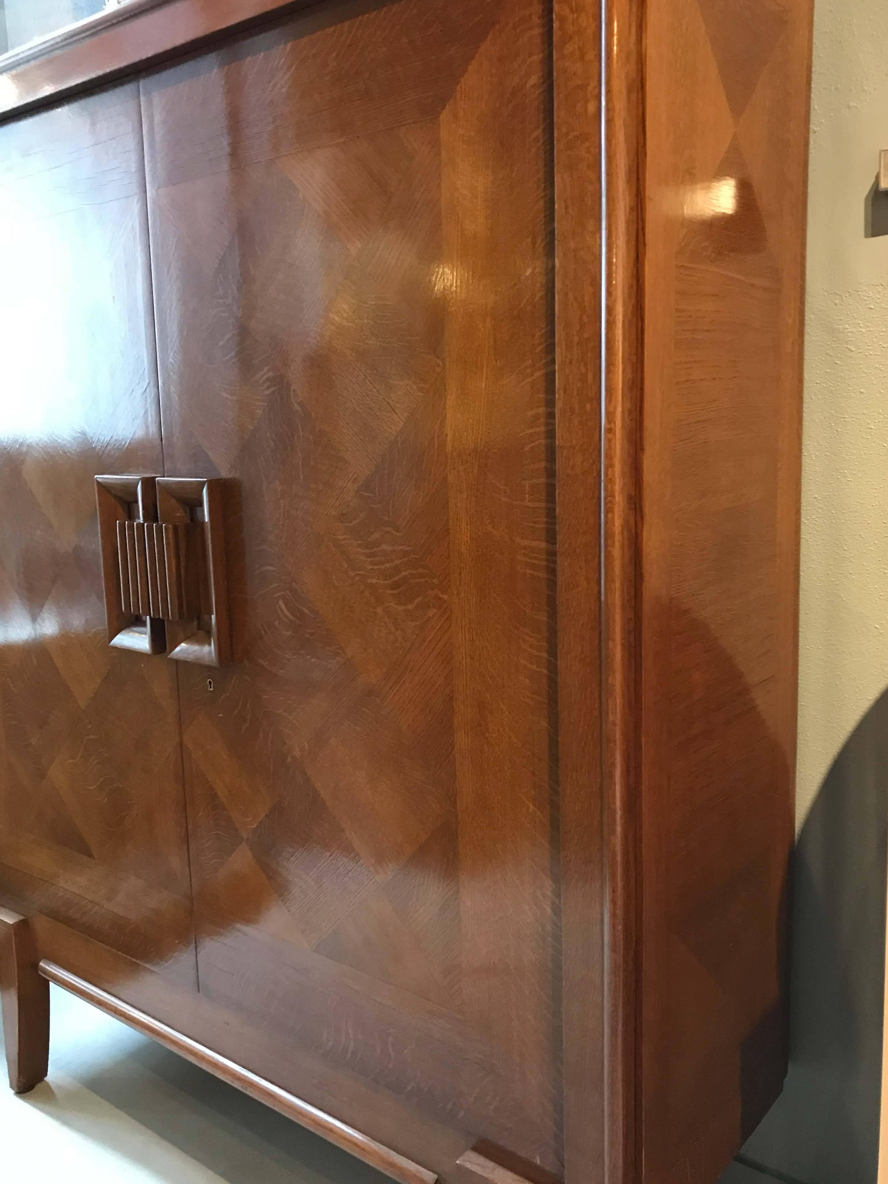 A beautiful art deco cabinet of exceptional quality. Geometric marquetry covers the exterior surfaces with double doors that open to reveal an open cabinet.

Restored circa 2000, condition shows minor wear consistent with use since. Back has a hole