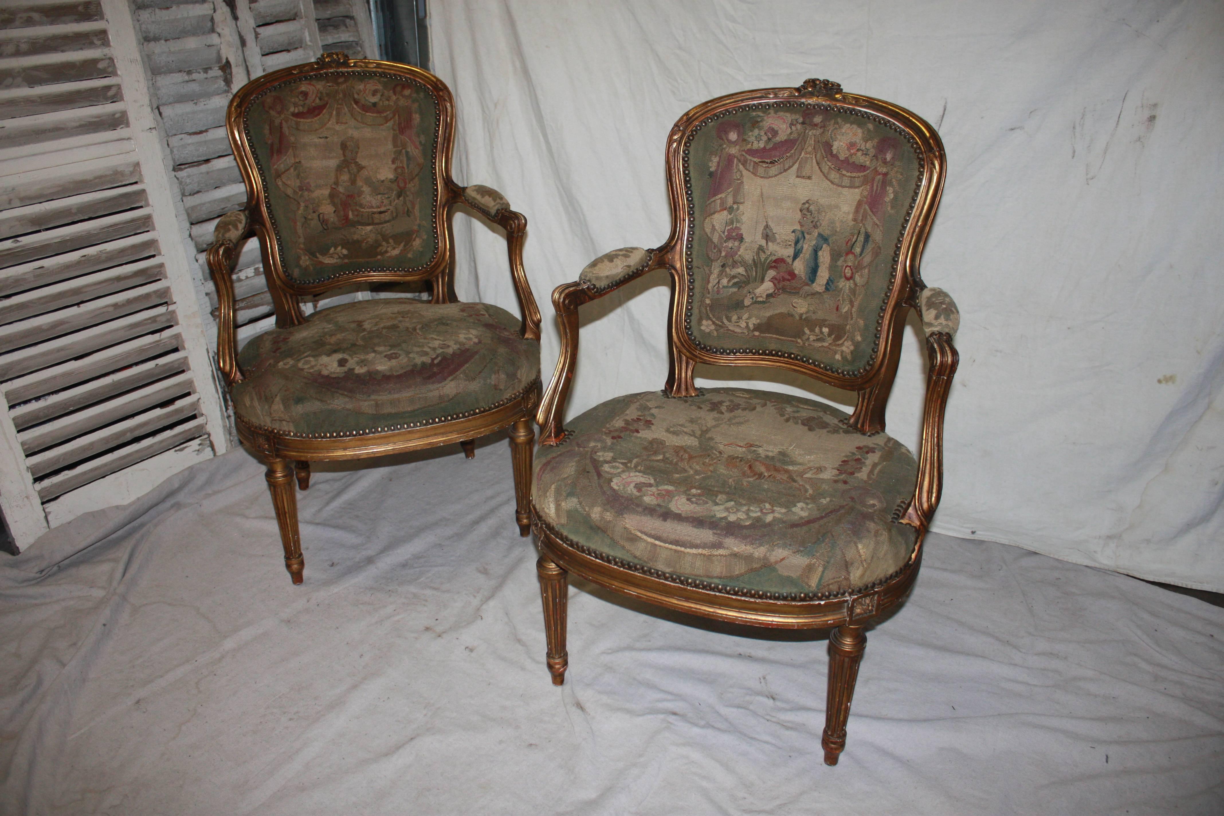 Pair of 19th century French gilded armchairs covered with an old tapestry.