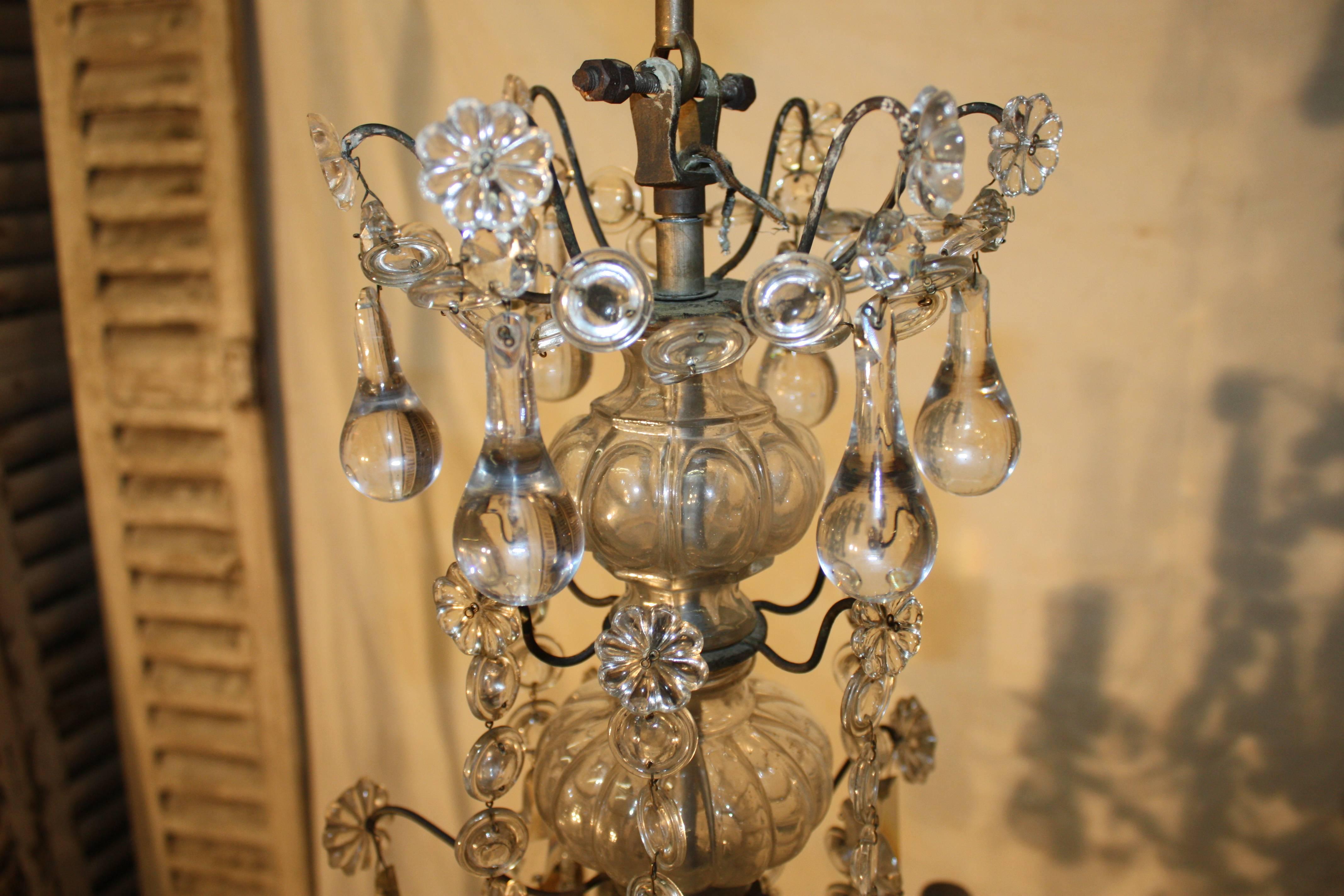 19th century French chandelier. The structure is in iron. The chandelier is ornate of glass tassels.