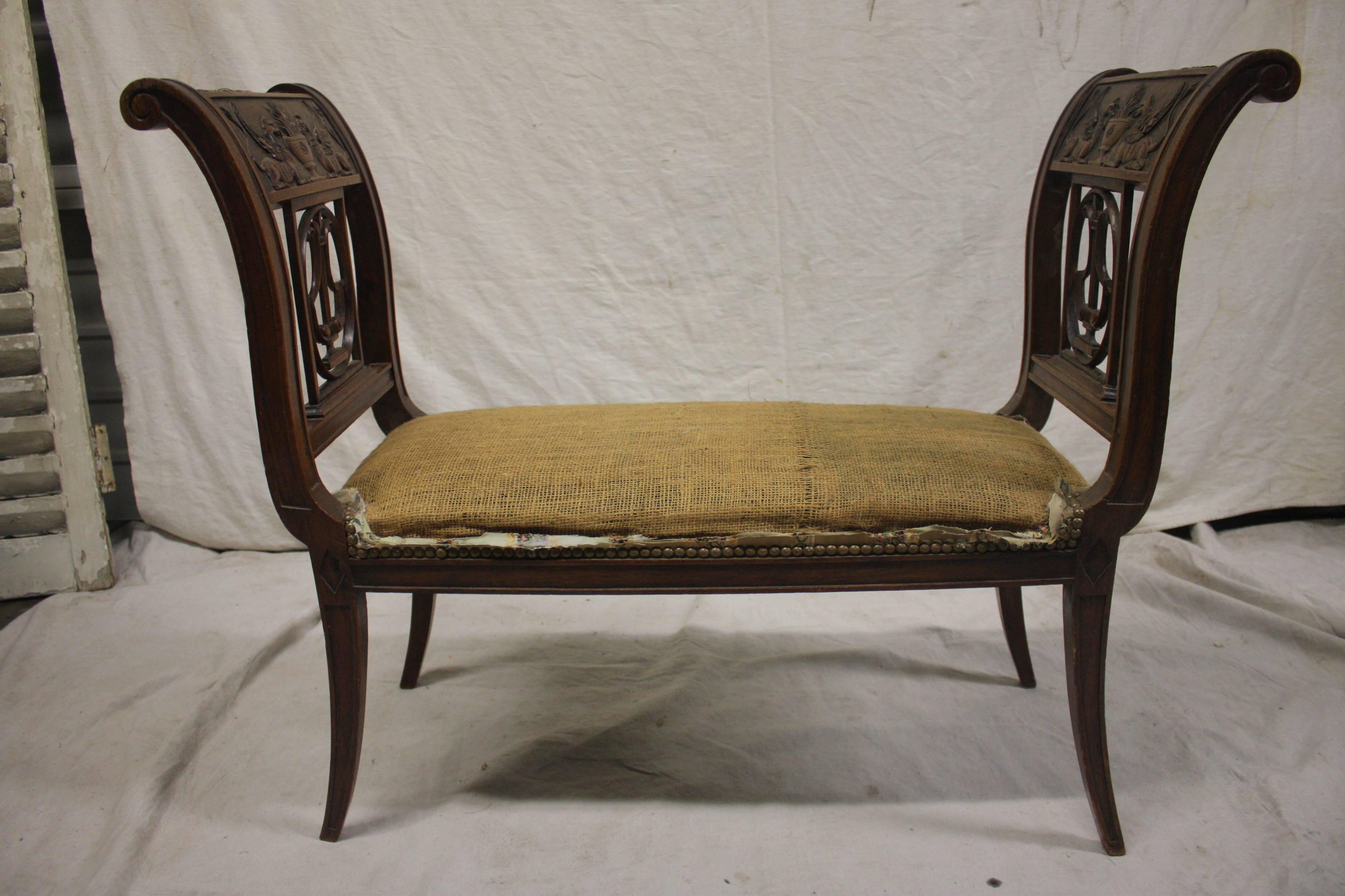 Charming French Directoire style bench. The wood is carved walnut, mid-19th century.