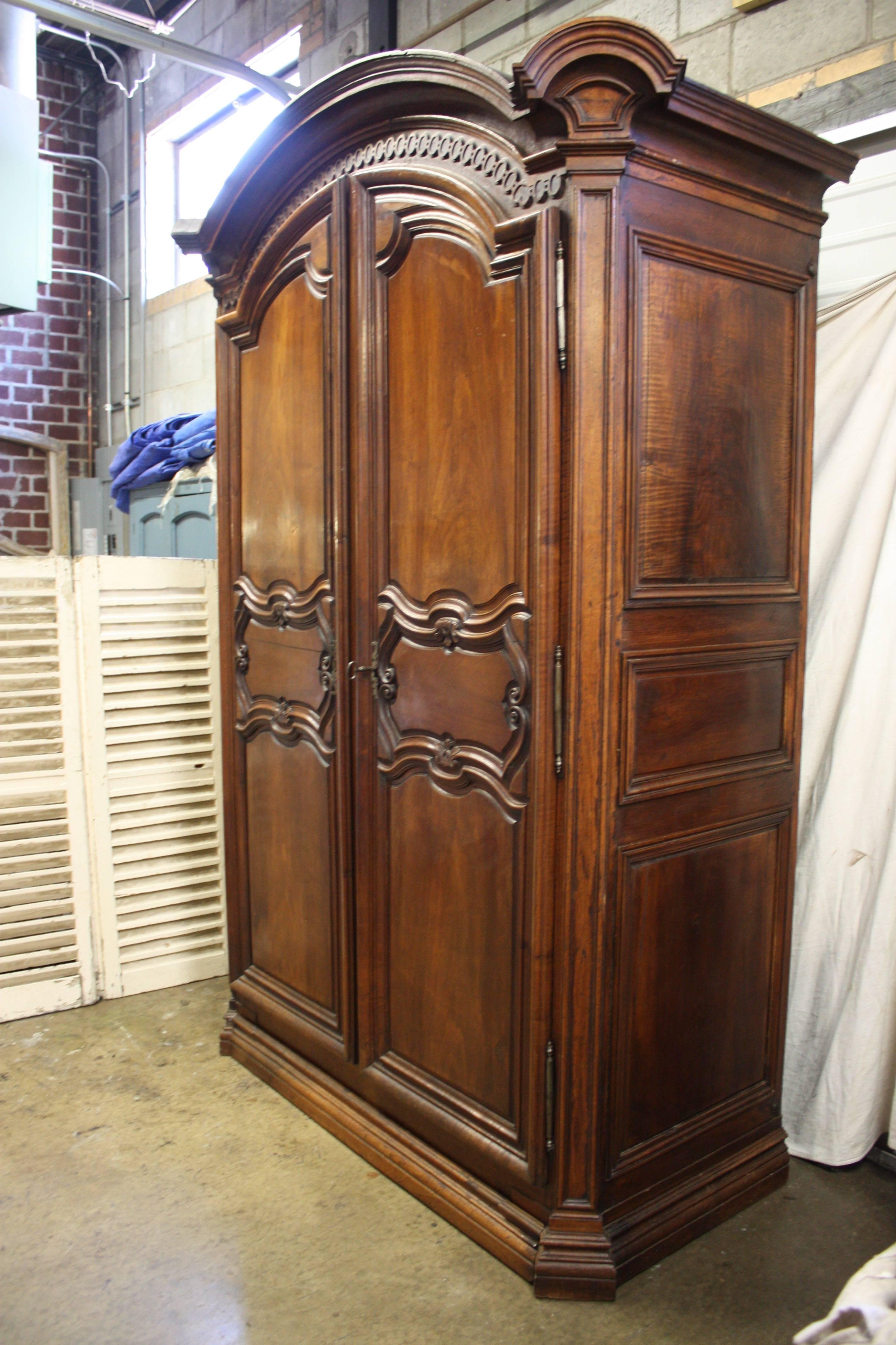 Gorgeous 18th century French wardrobe. The wood is in walnut, carved and the inside doors wears an 18th century lock.