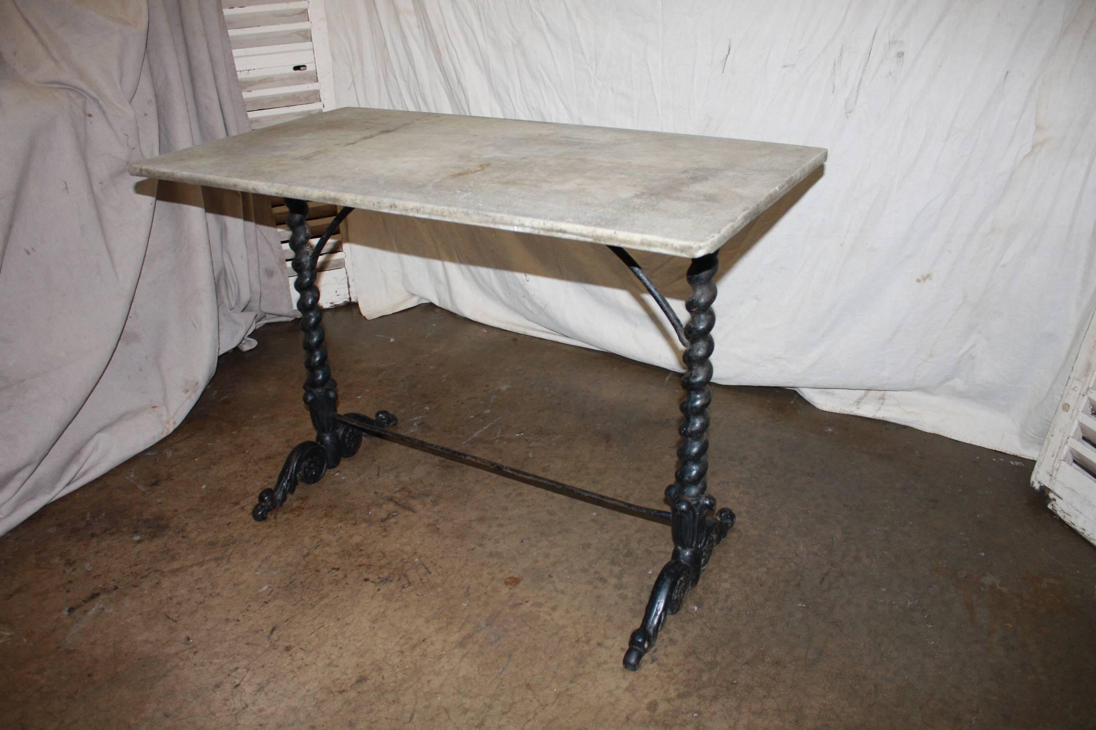 This beautiful garden or bistro table is in cast iron and wear a top made of stone, Louis XIV style.
