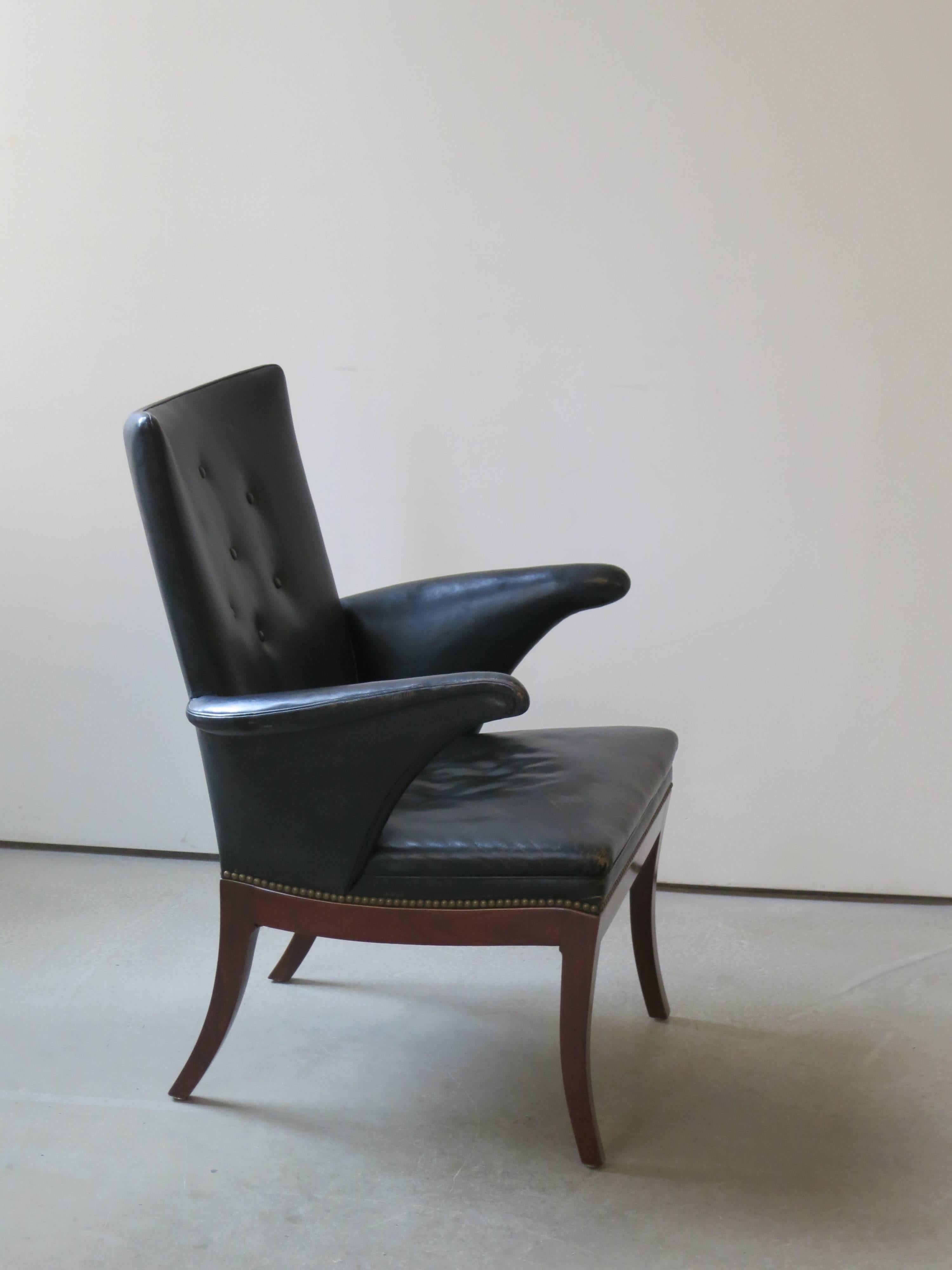 1930s Armchair in Original Black Leather by Frits Henningsen. This chair, which dates to the 1930s, retains its original patinated black leather upholstery and brass nailheads.