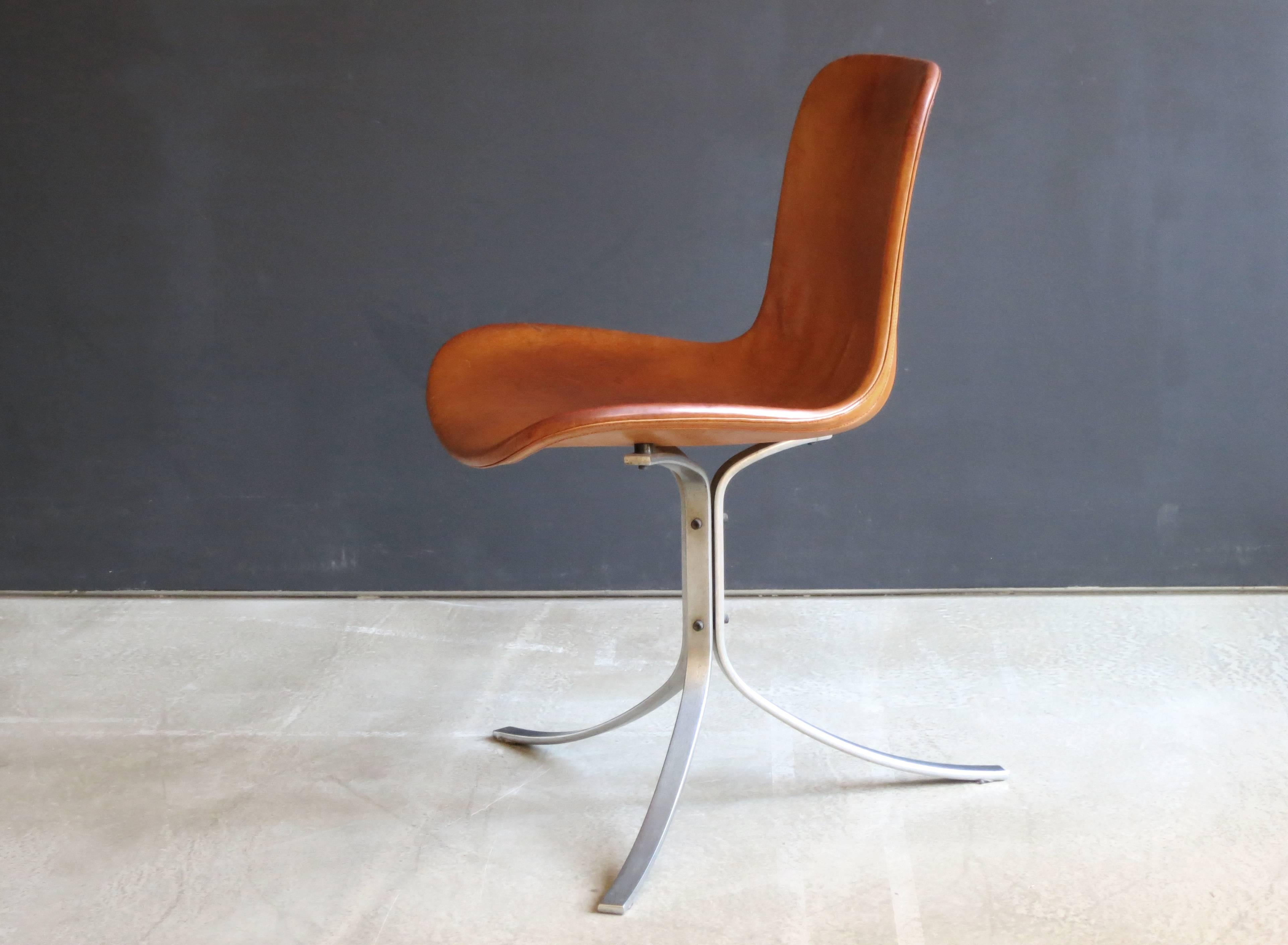 Designed in 1960 and considered one of Kjærholm's masterpieces as well as a masterpiece among all 20th century chairs, the leather seat and back of this chair floats on three beautifully curved matte chrome-plated steel legs. Its minimalist design