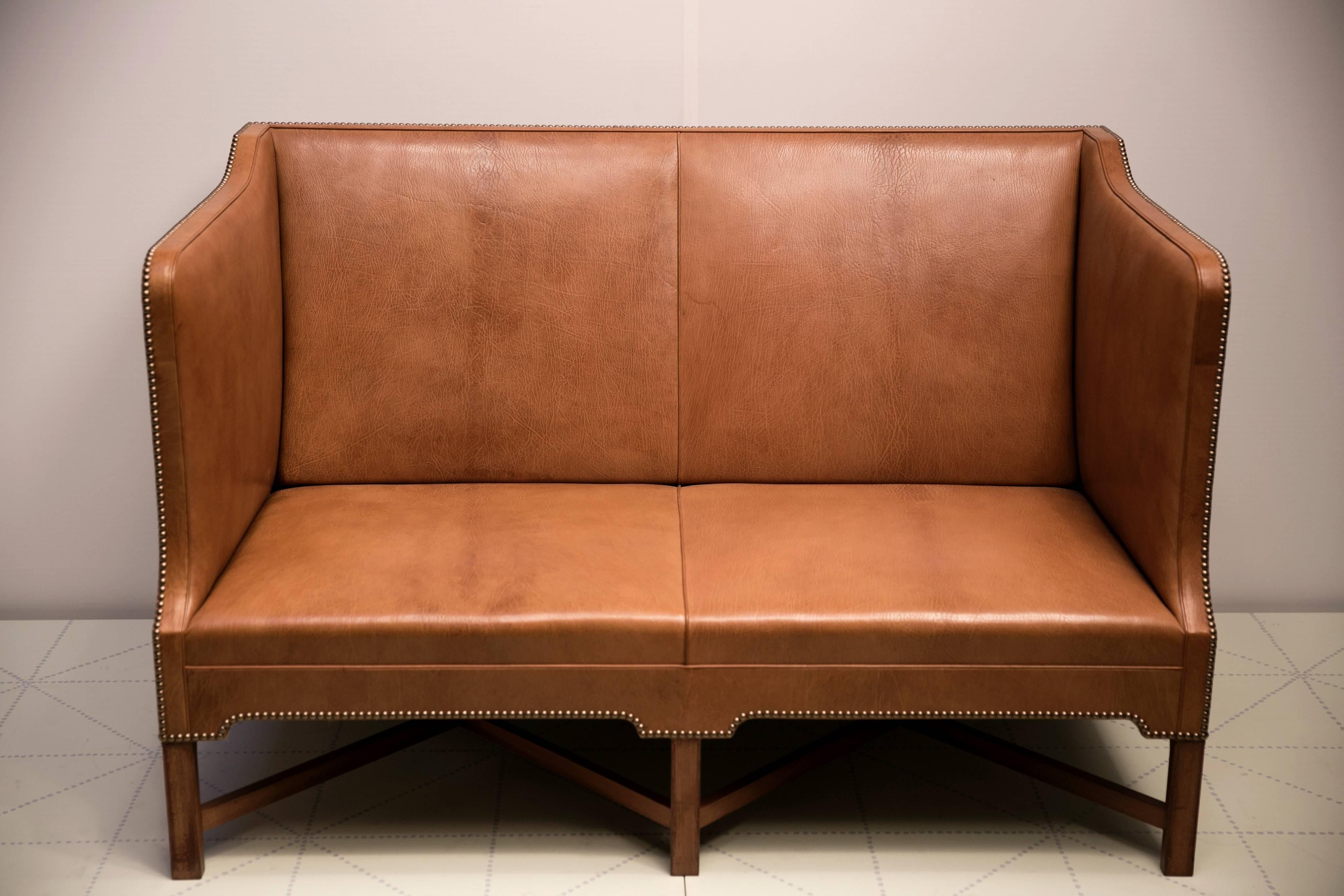 Offered by Vance Trimble, 2 1/2 Person Sofa in Nigerian Goatskin on Cuban Mahogany Legs by Kaare Klint. Made by master cabinetmaker Rud. Rasmussens Snedkerier.

Upholstered in natural Nigerian goatskin with brass nails on Cuban mahogany