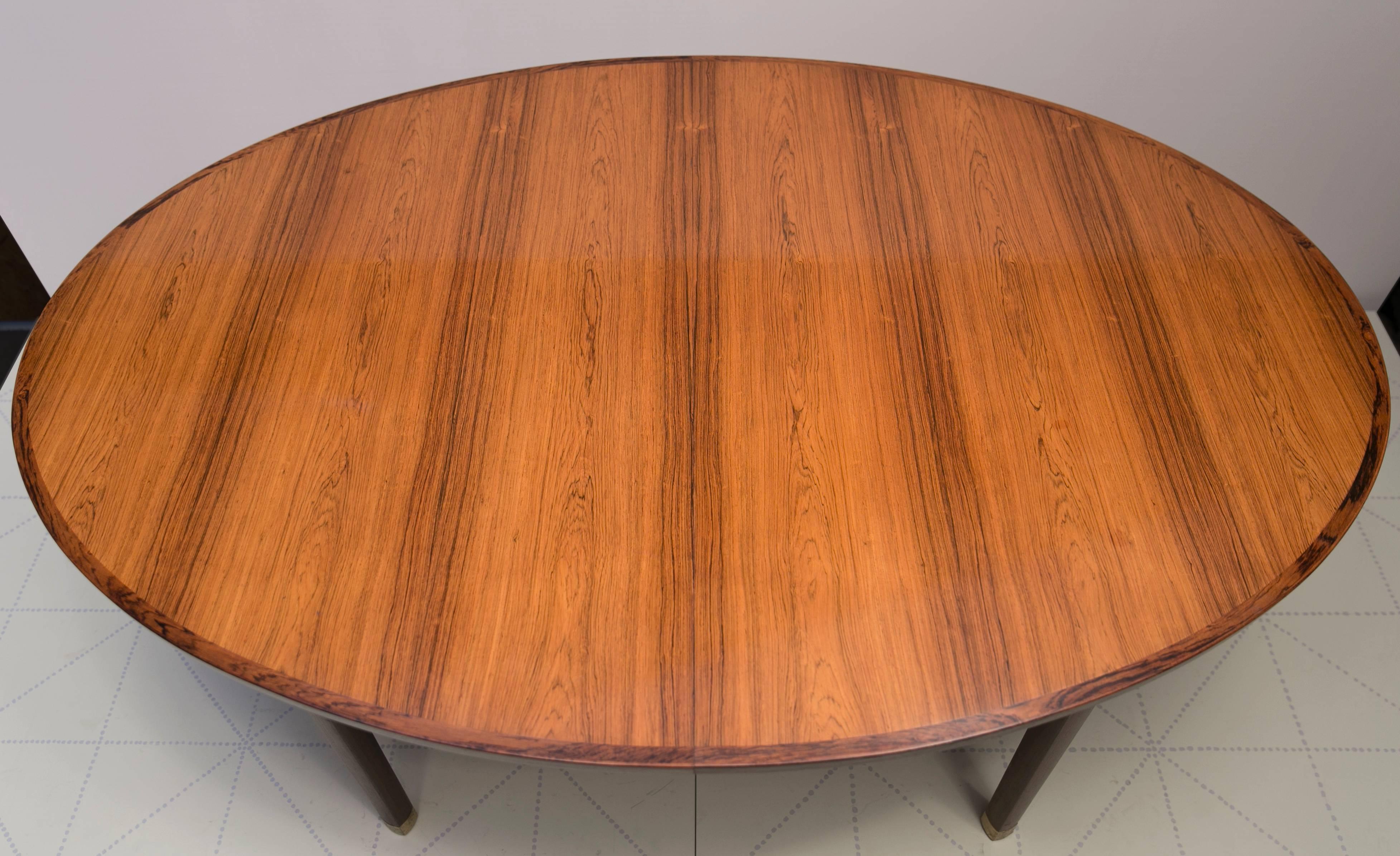 This dining table stands out for its simple yet highly sophisticated and beautiful lines. The top is constructed of high quality Brazilian rosewood veneer surrounded by molded solid rosewood edging. The legs and apron also display beautiful sculpted